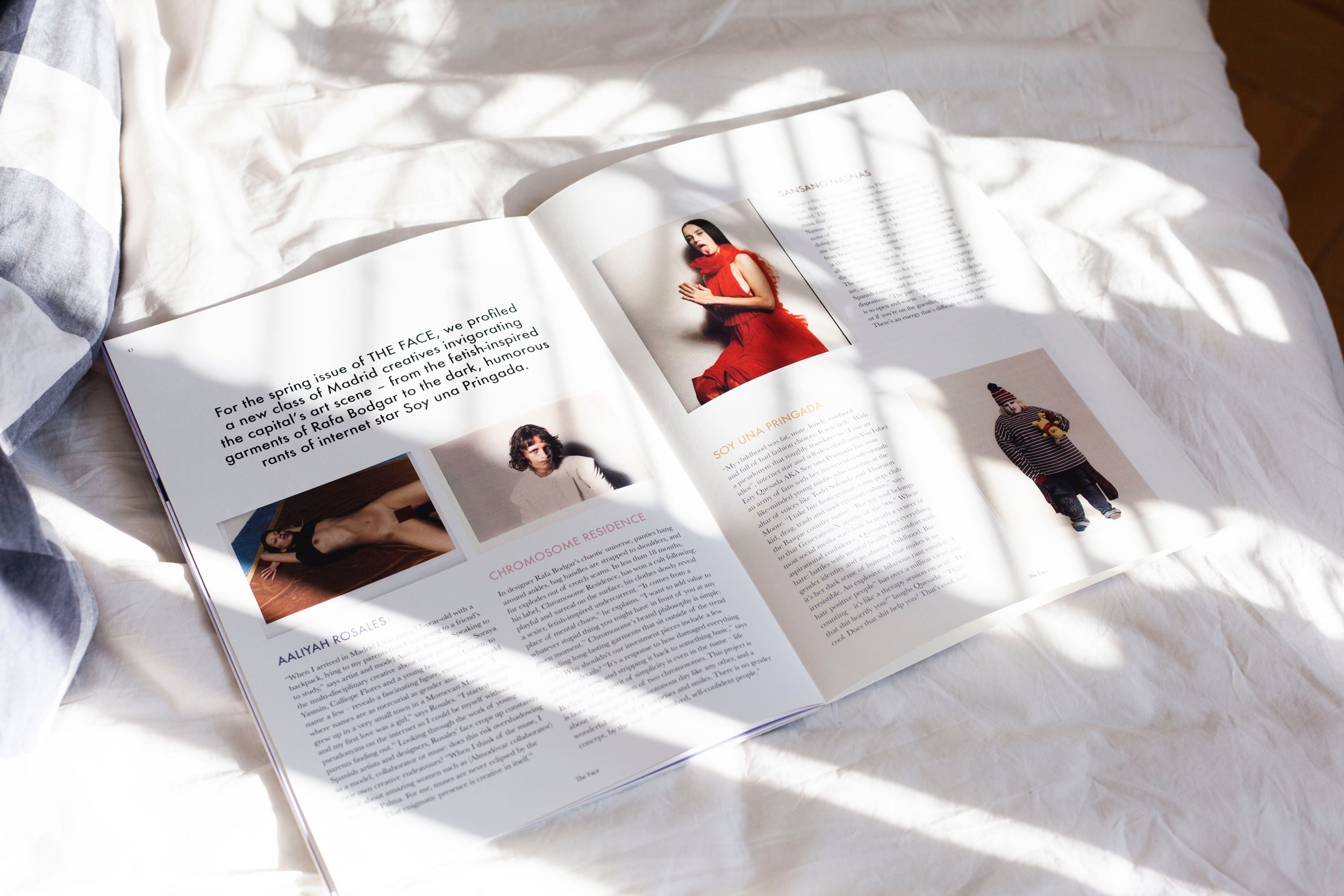 A fashion magazine is open on a white surface