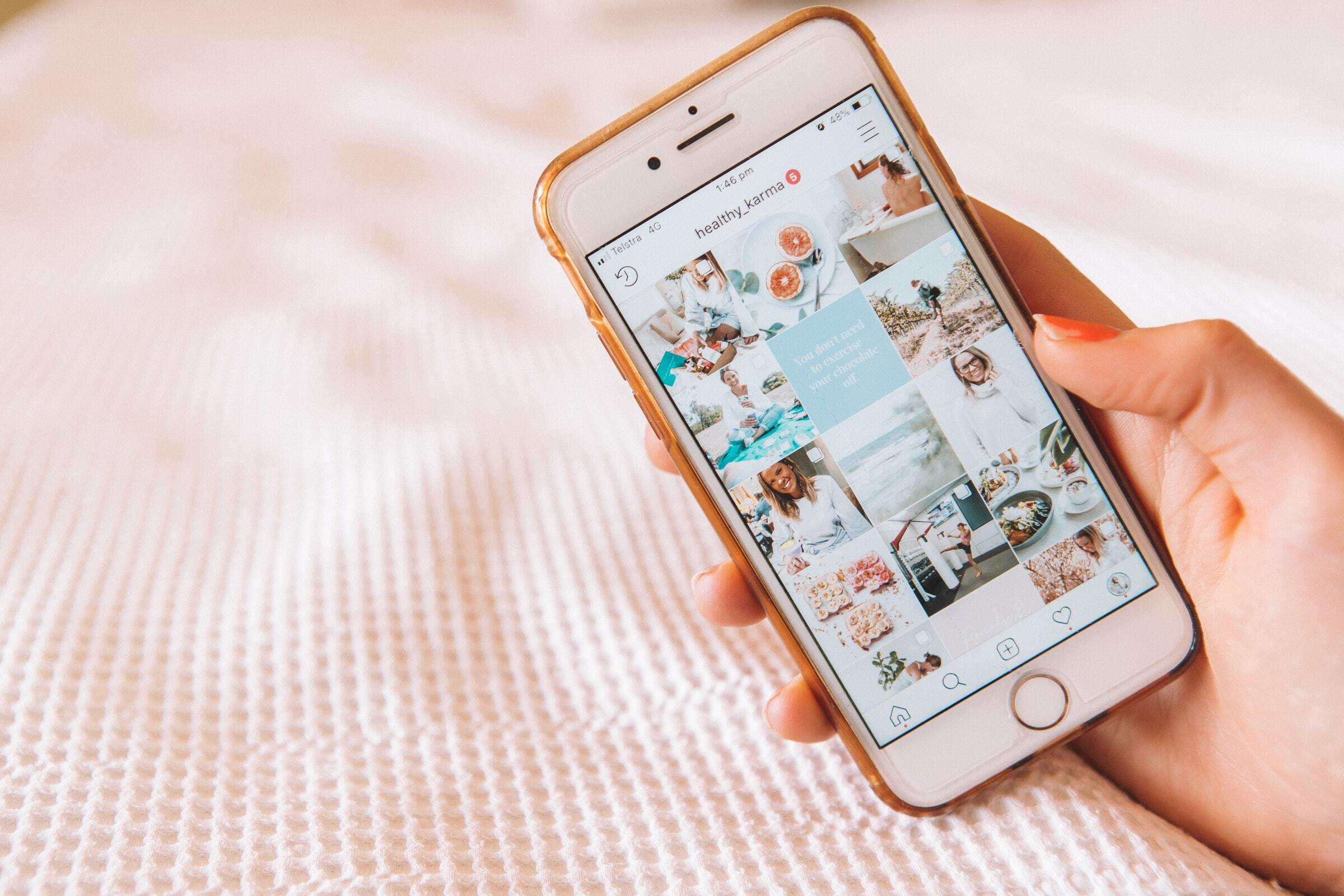 maddie bazzocco/unsplash - hand holding smartphone, screen has influencer inages - influencer pricing rates