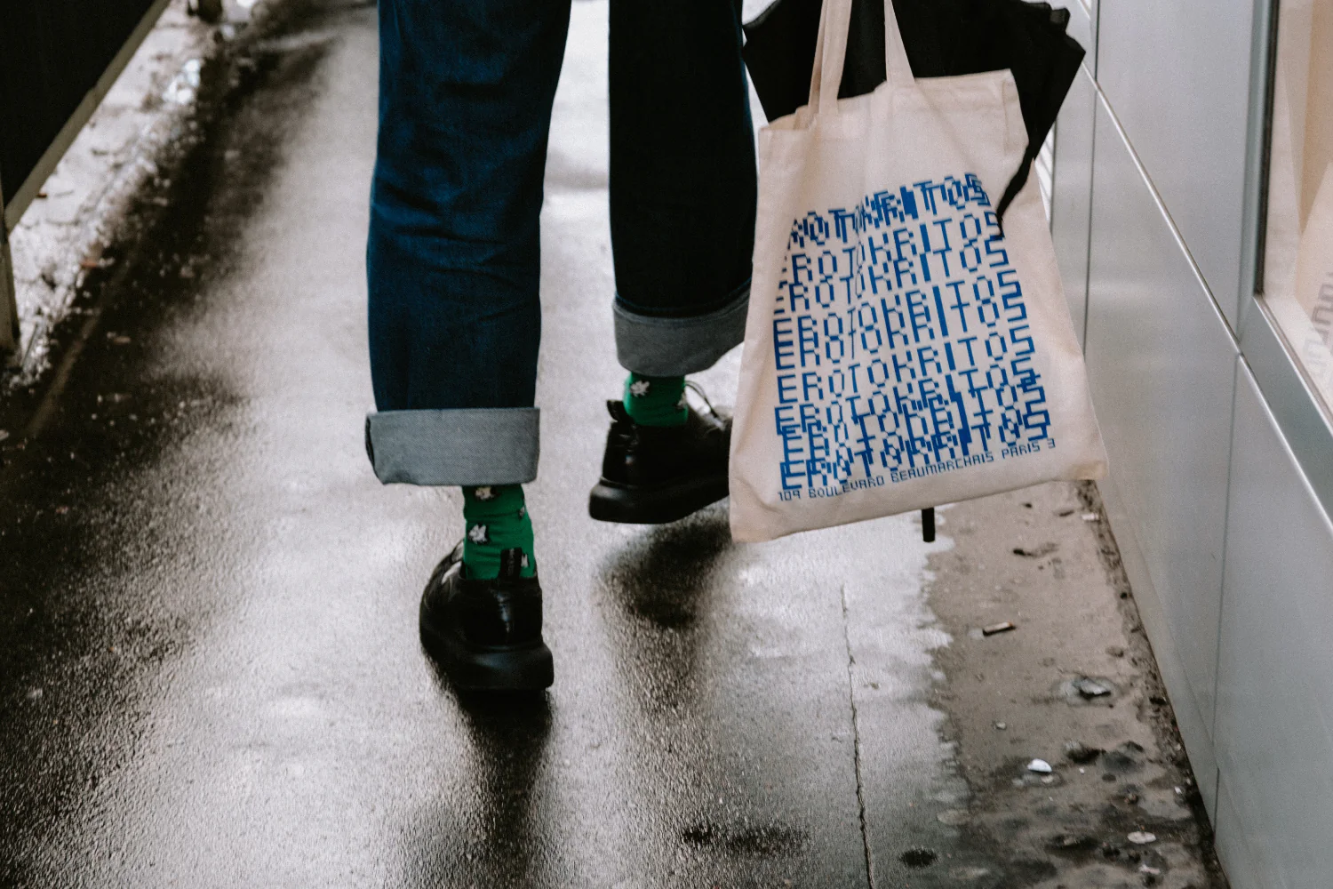 A person walks away carrying a printed tote bag