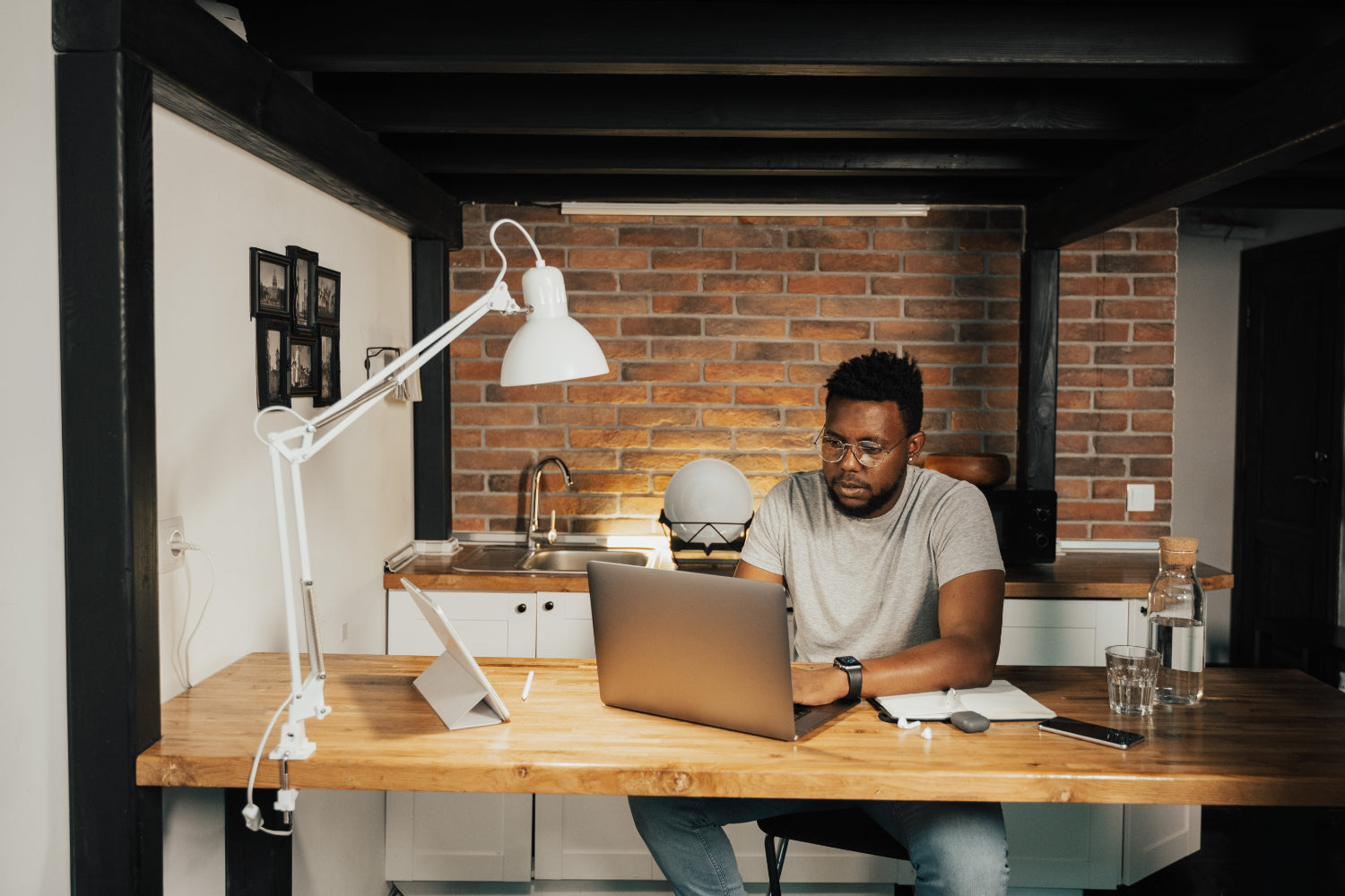 Een man verdient online geld terwijl hij aan een bureau in een thuiskantoor werkt op een laptop