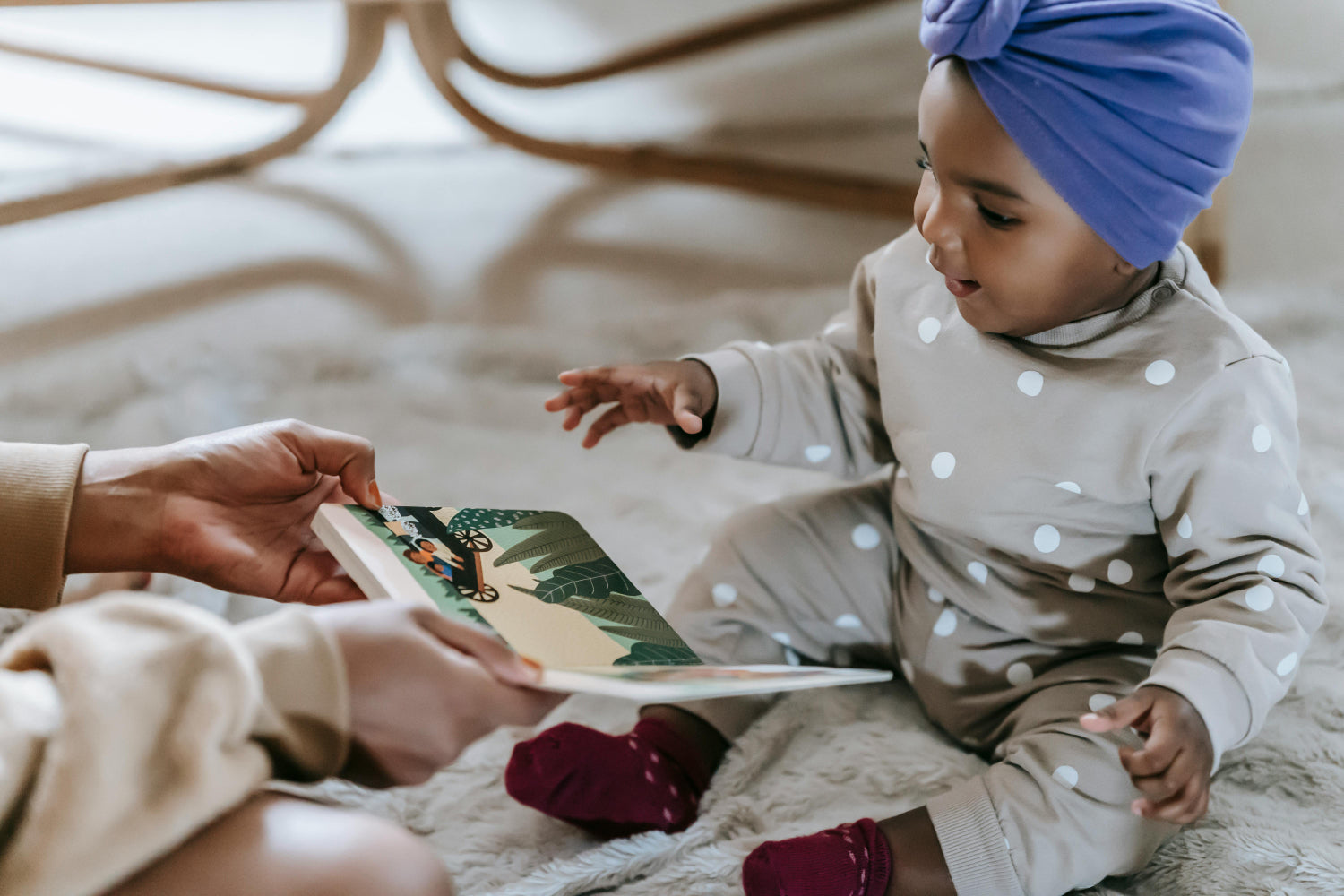 A child sits on the floor among toys and a book