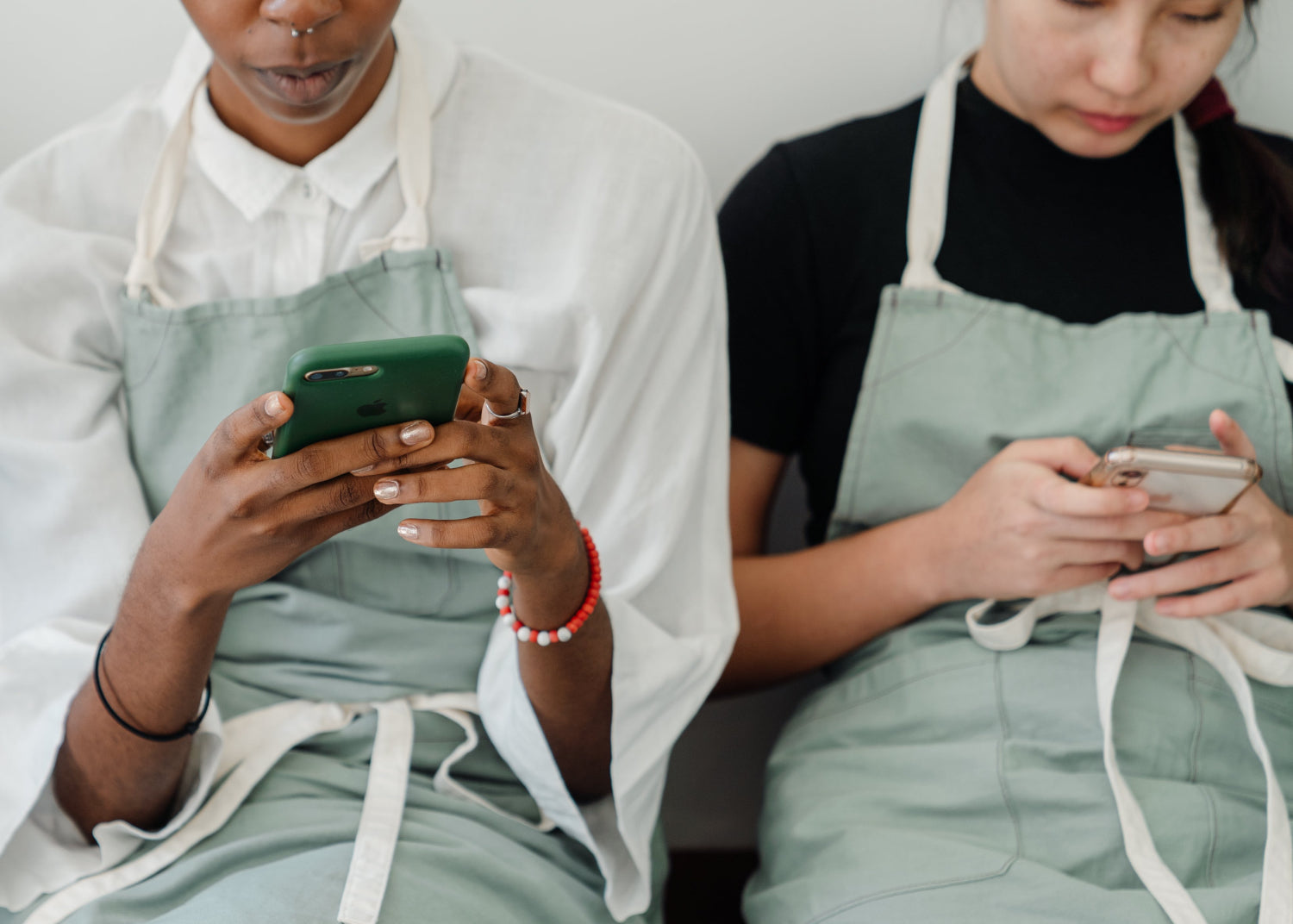 Two people type on mobile phones