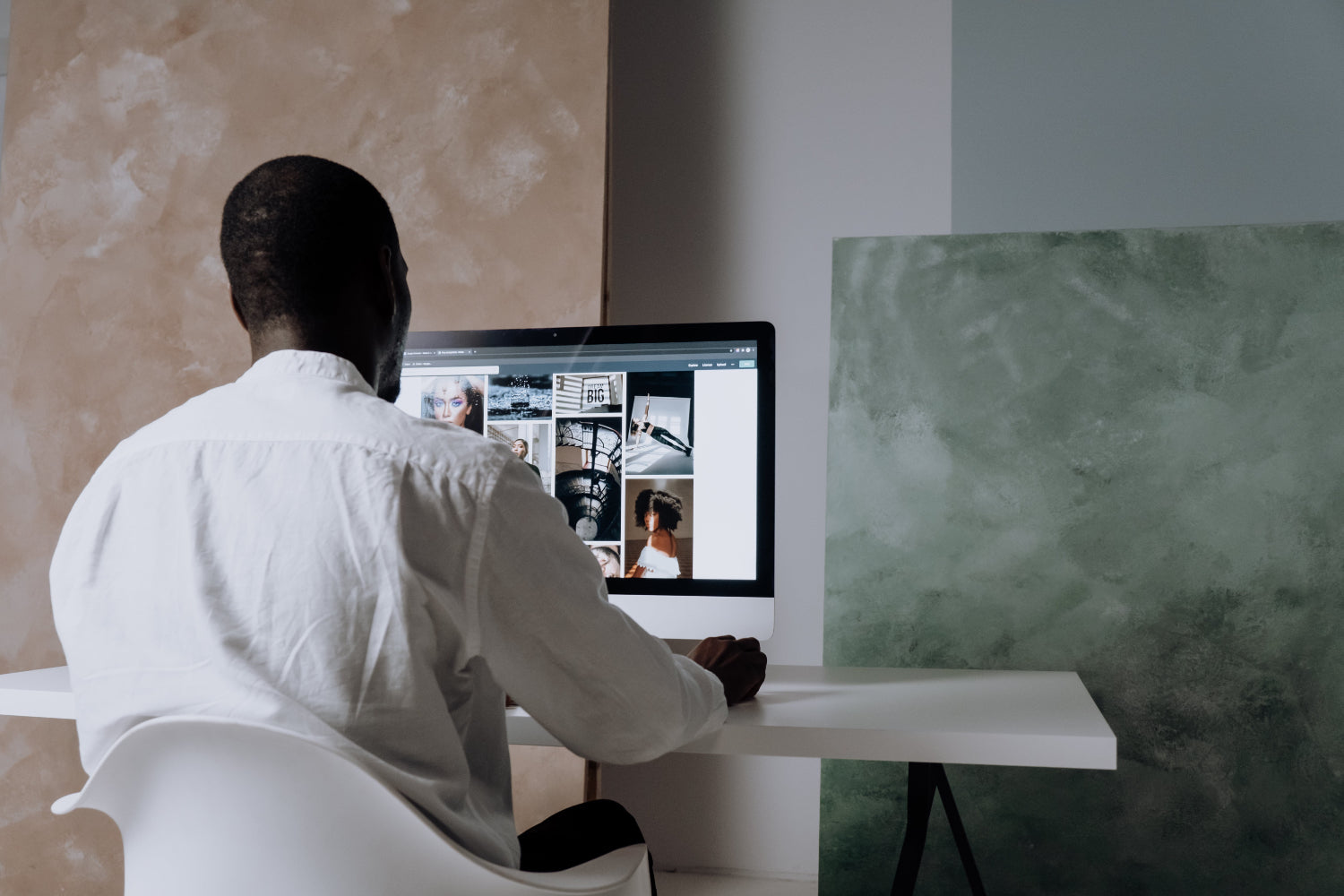 A man browses photos on a desktop computer