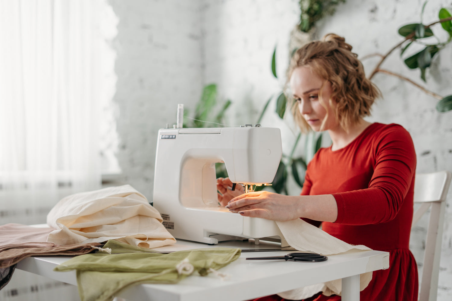 A woman sews fabric on a sewing machine