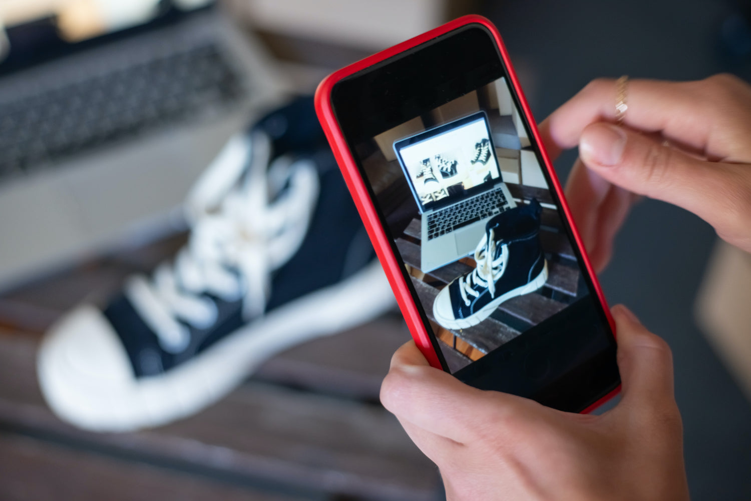 A person takes a photo of a sneaker with a mobile phone