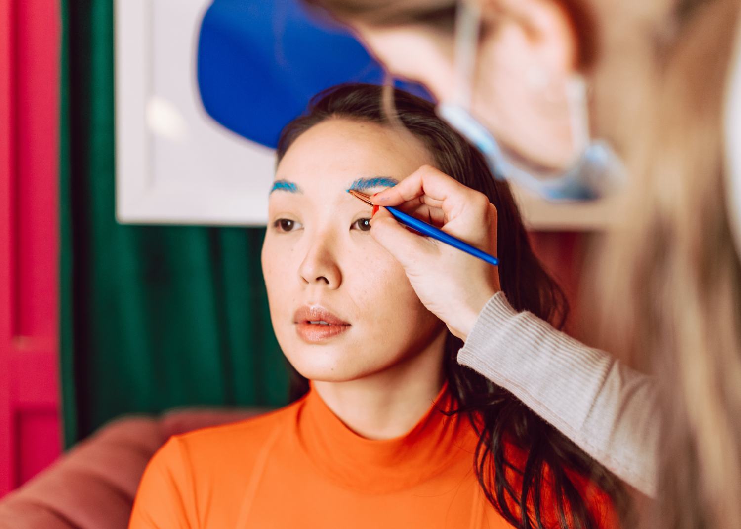 A persona applies make up to a model