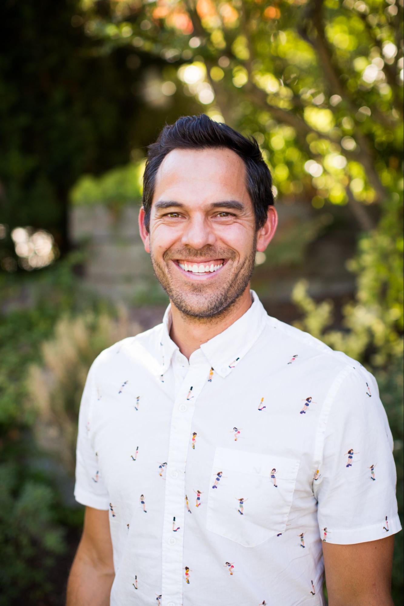 Founder of MiiR, Bryan Papé, wearing a white button down with greenery in the background