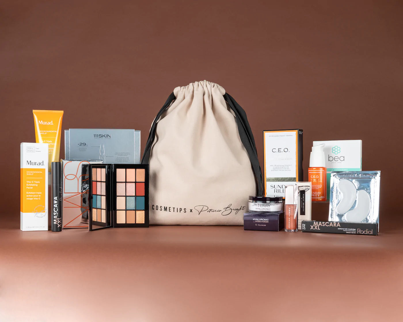 An array of beauty products arranged around a canvas bag