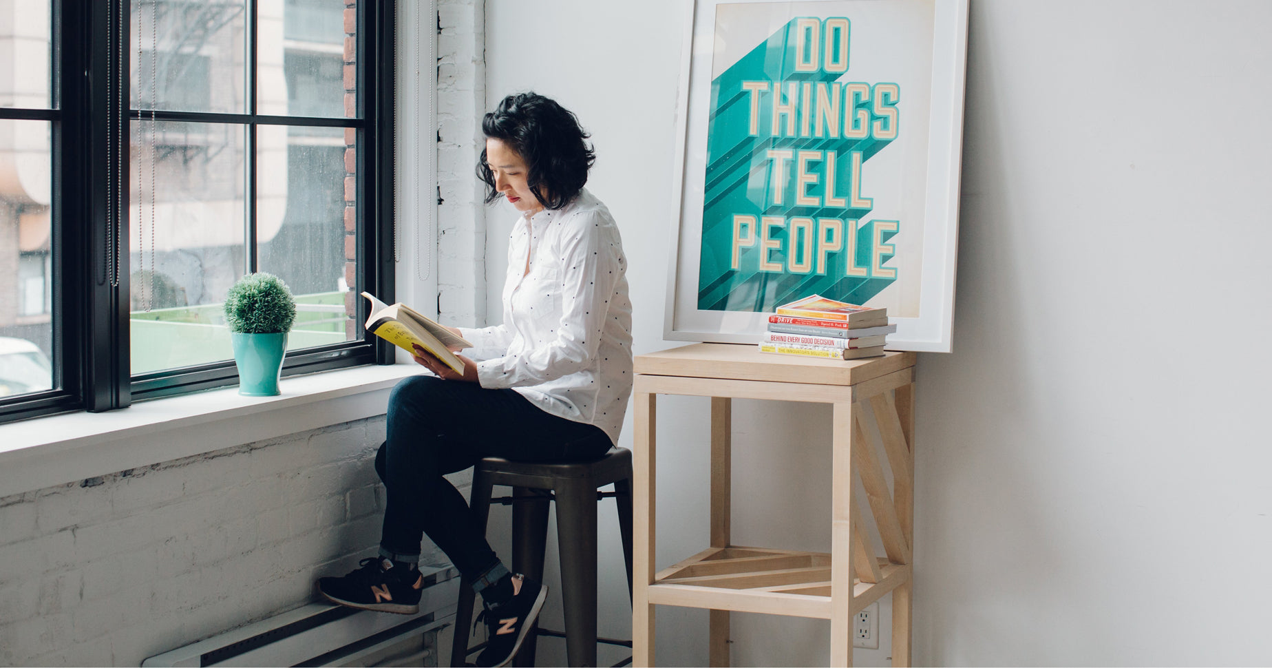 Woman reading success quotes by window