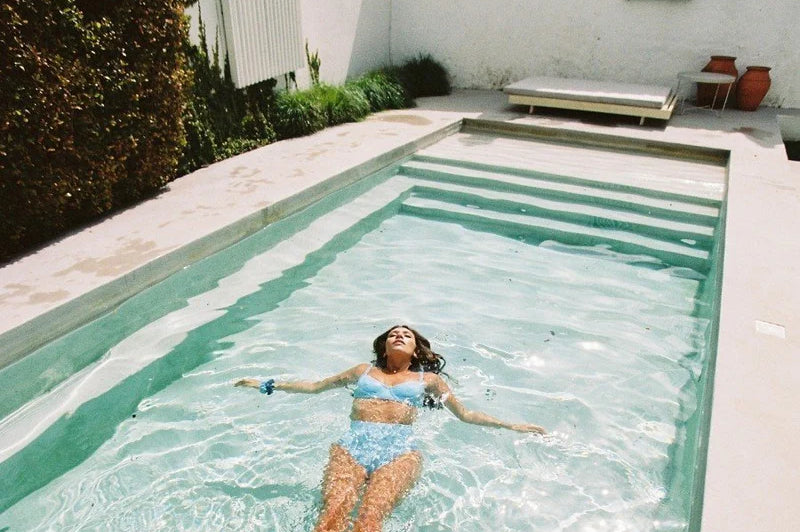 A woman floats on her back in a swimming pool