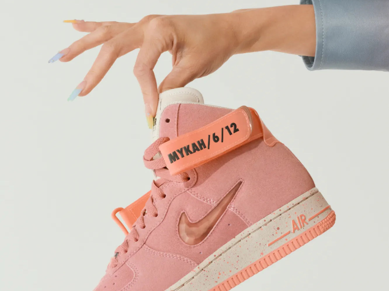 Image of a Nike By You shoe held by a woman's hand