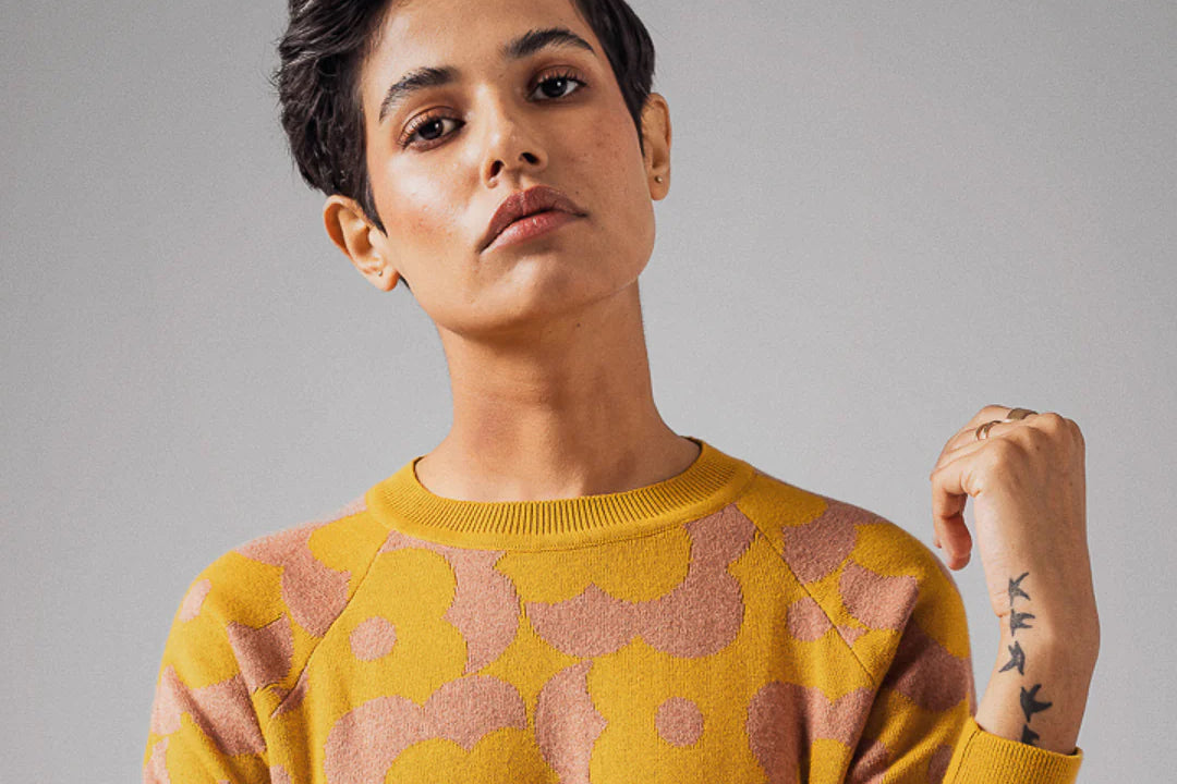 A person models a sustainably made sweater
