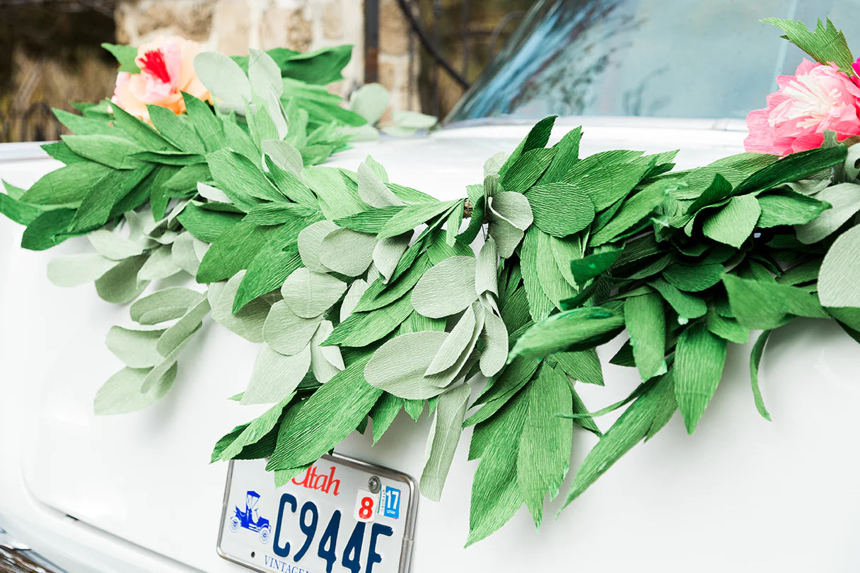 Crafts you can make and sell include a garland of paper flowers arranged on a car