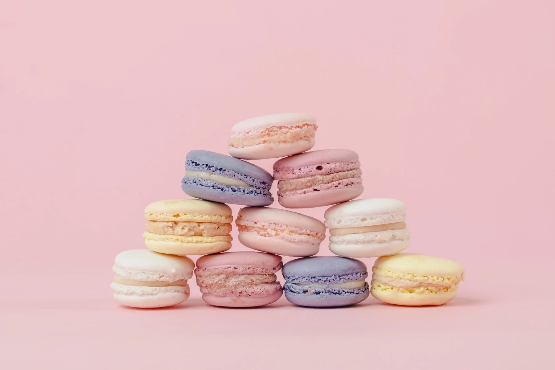 Macarons stacked against a pink backdrop