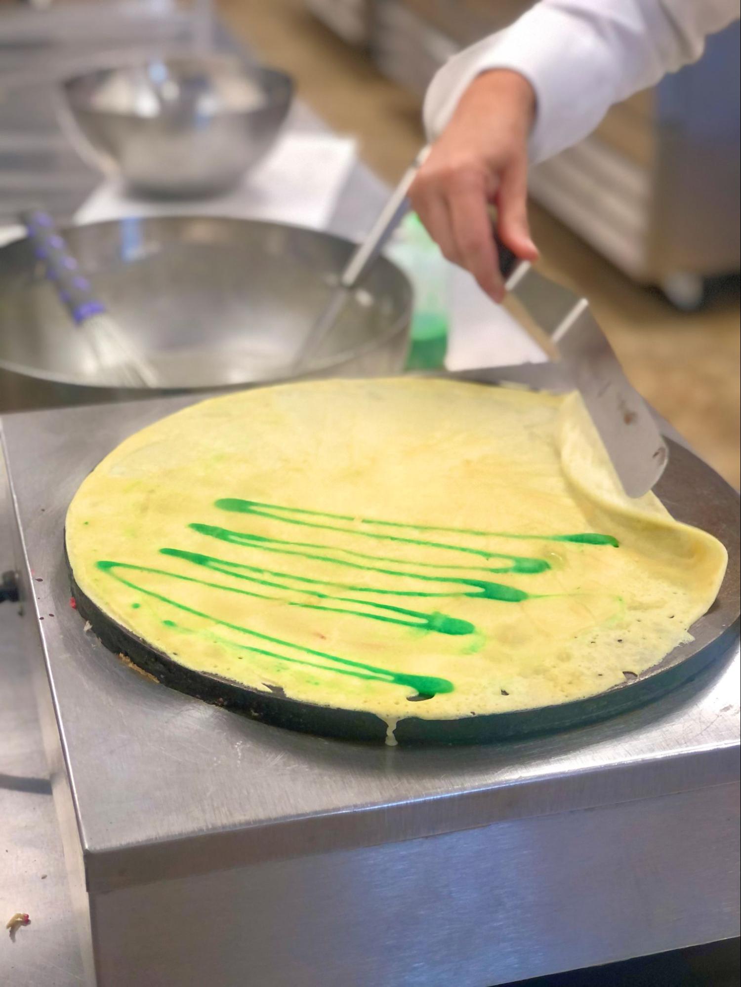 A crepe being flipped on a crepes pan.