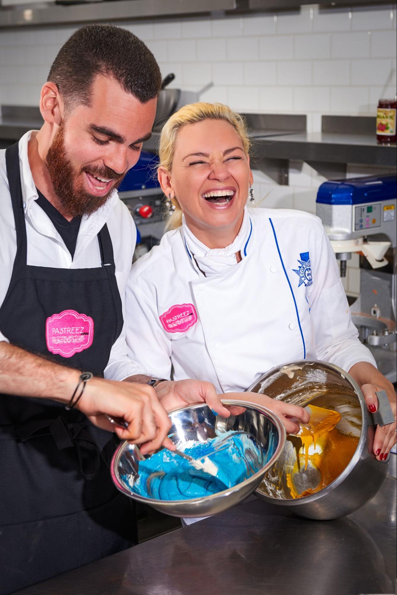 Yami and Anthony Rosemond wearing chef whites working together in a kitchen.