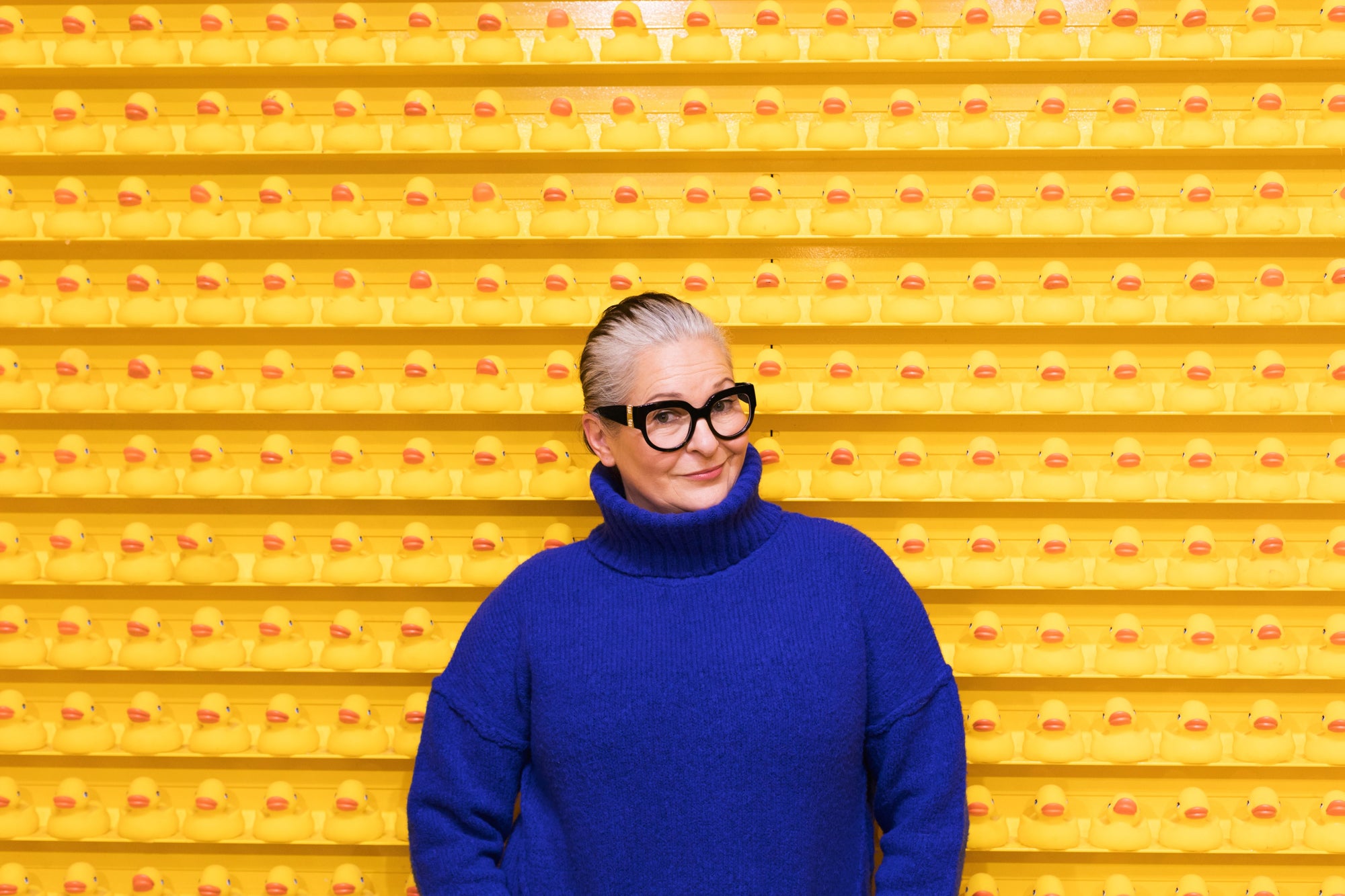 Portret van een oudere vrouw voor een gele muur