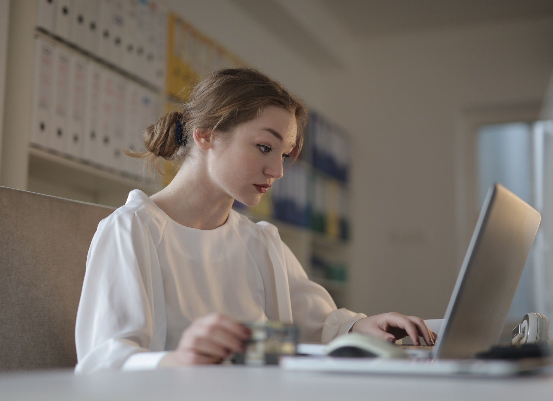 A woman sits in front of an open laptop screen