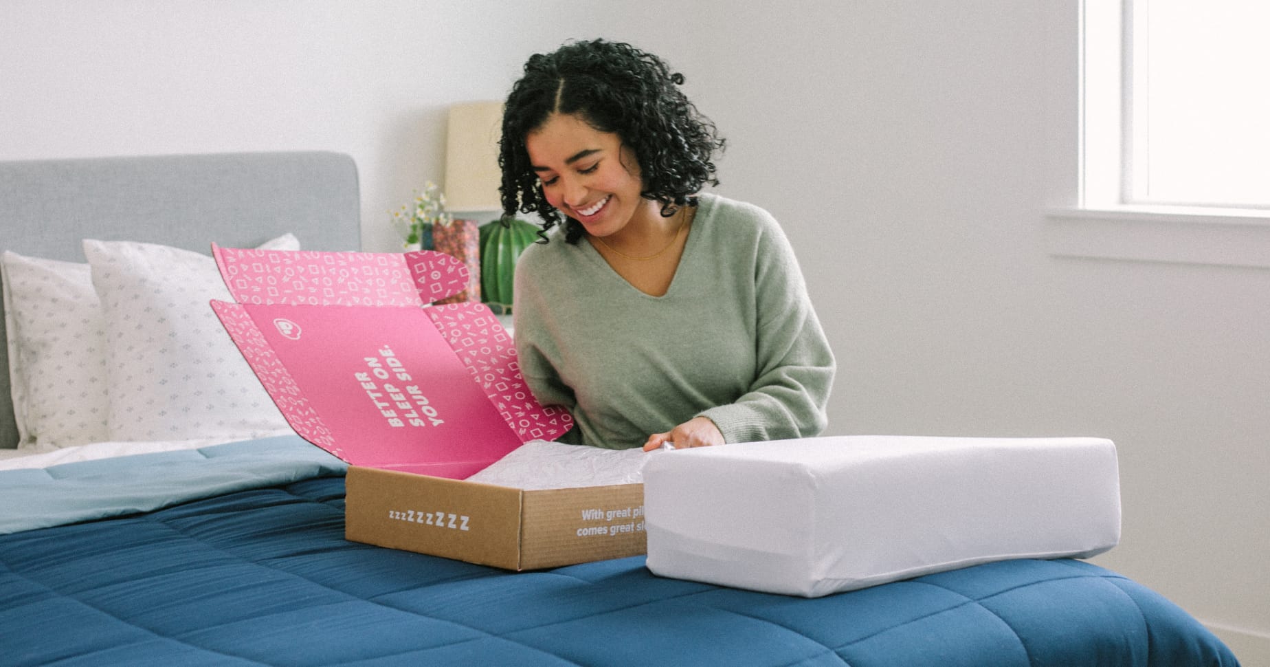 A Pillow Cube customer unboxing their purchase on their bed