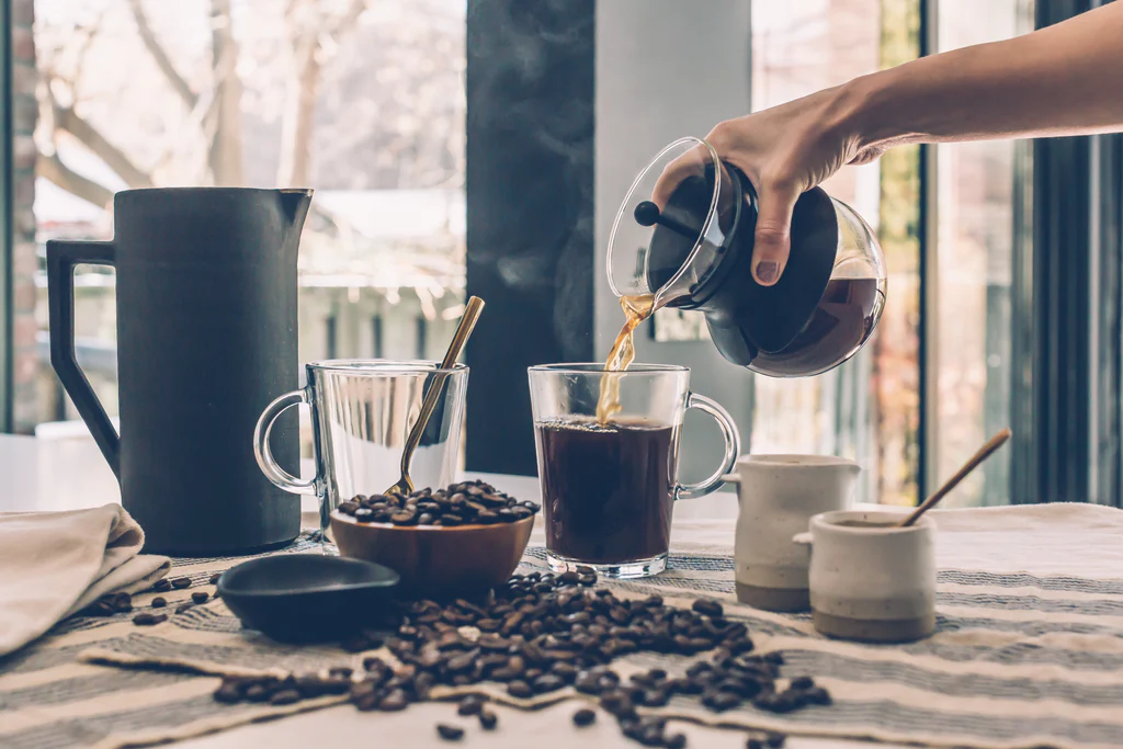 Persona che versa del caffè in una tazza