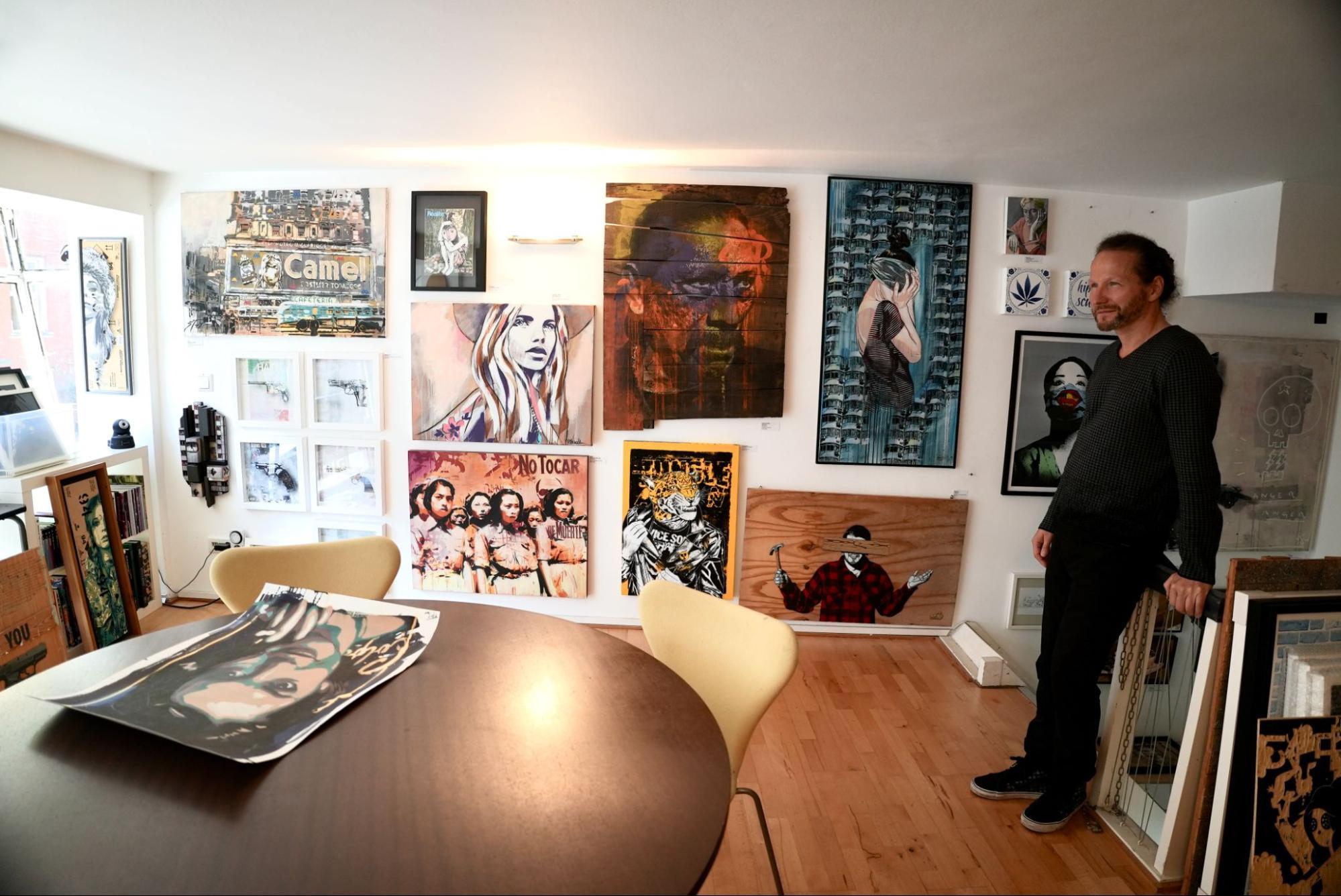 Klaus Rosskothen stands upstairs in thePretty Portal gallery, backdropped by a wall filled with urban contemporary art pieces. 