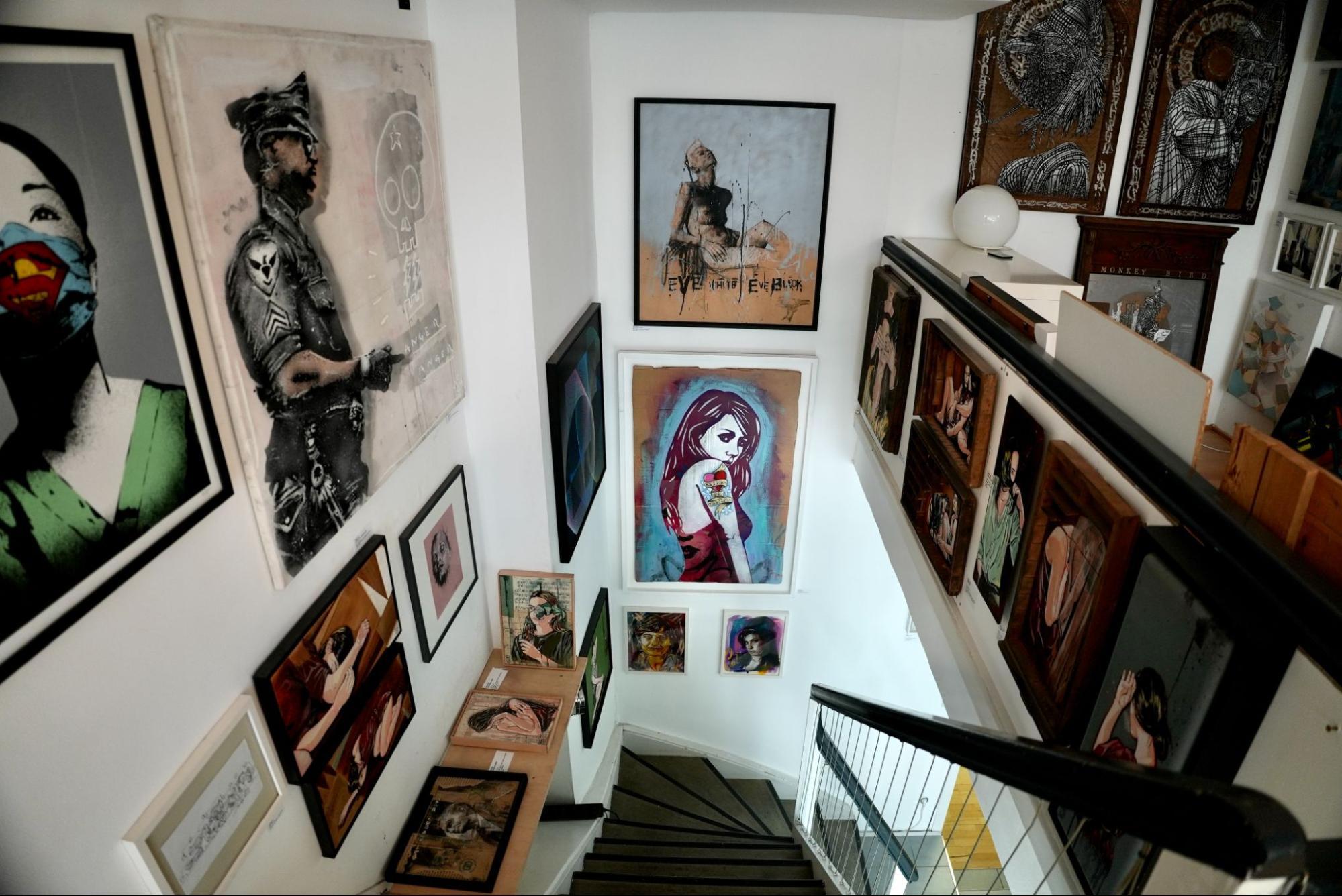 Collection of urban contemporary art pieces at a staircase section of Pretty Portal gallery.  