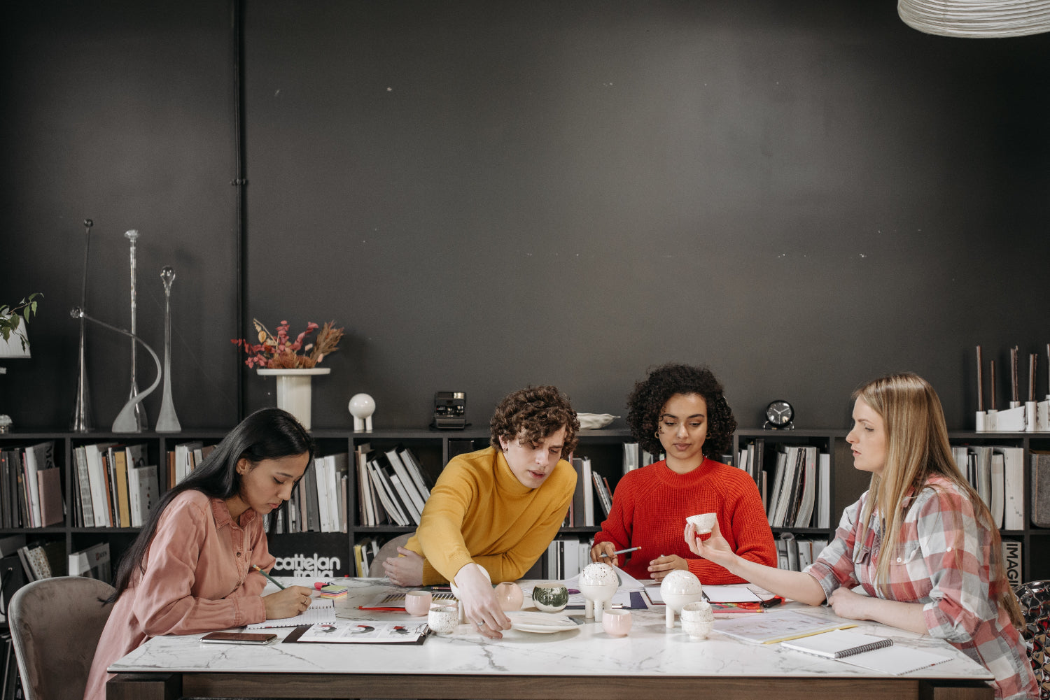 A diverse group of people works together at a long table