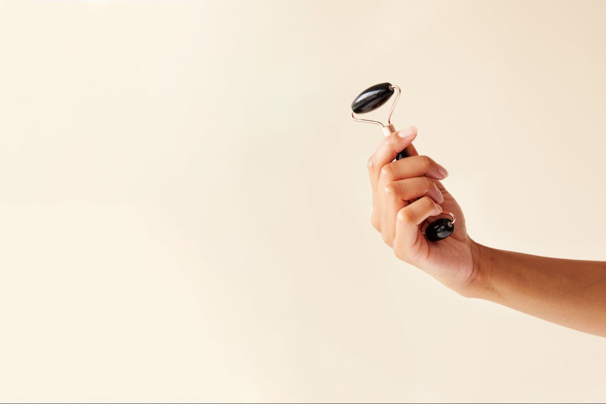 A person holding a white-label cosmetics product.