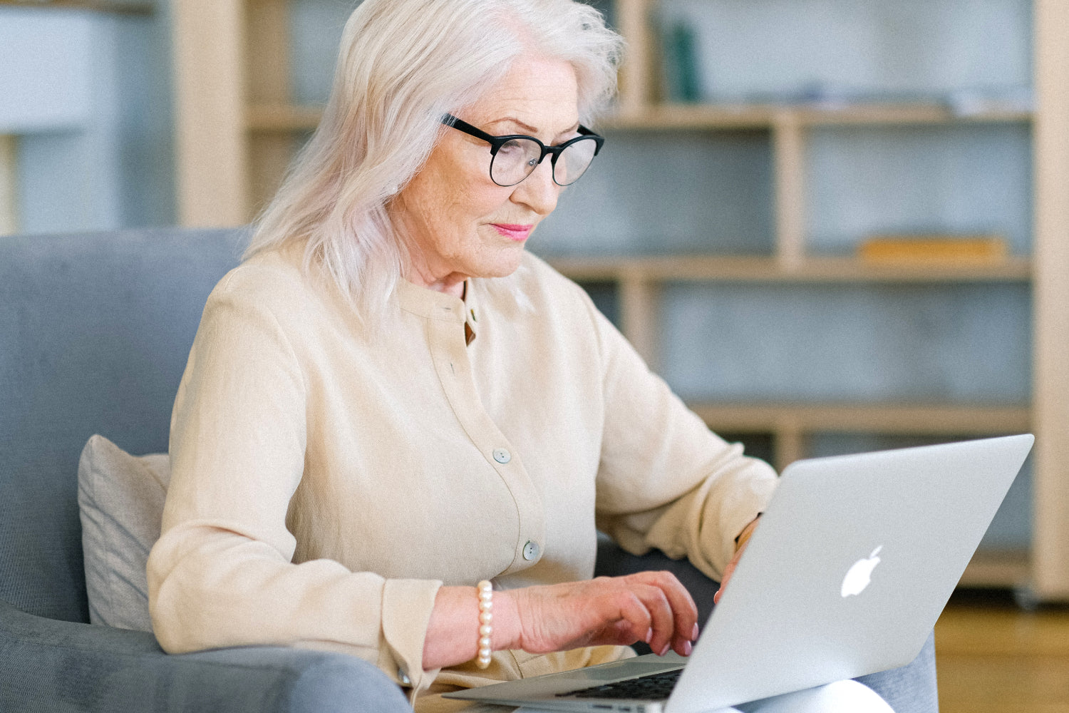 An older woman uses a laptop