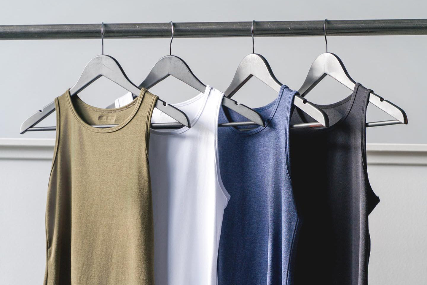 Organic cotton tank tops hang on a clothing rack