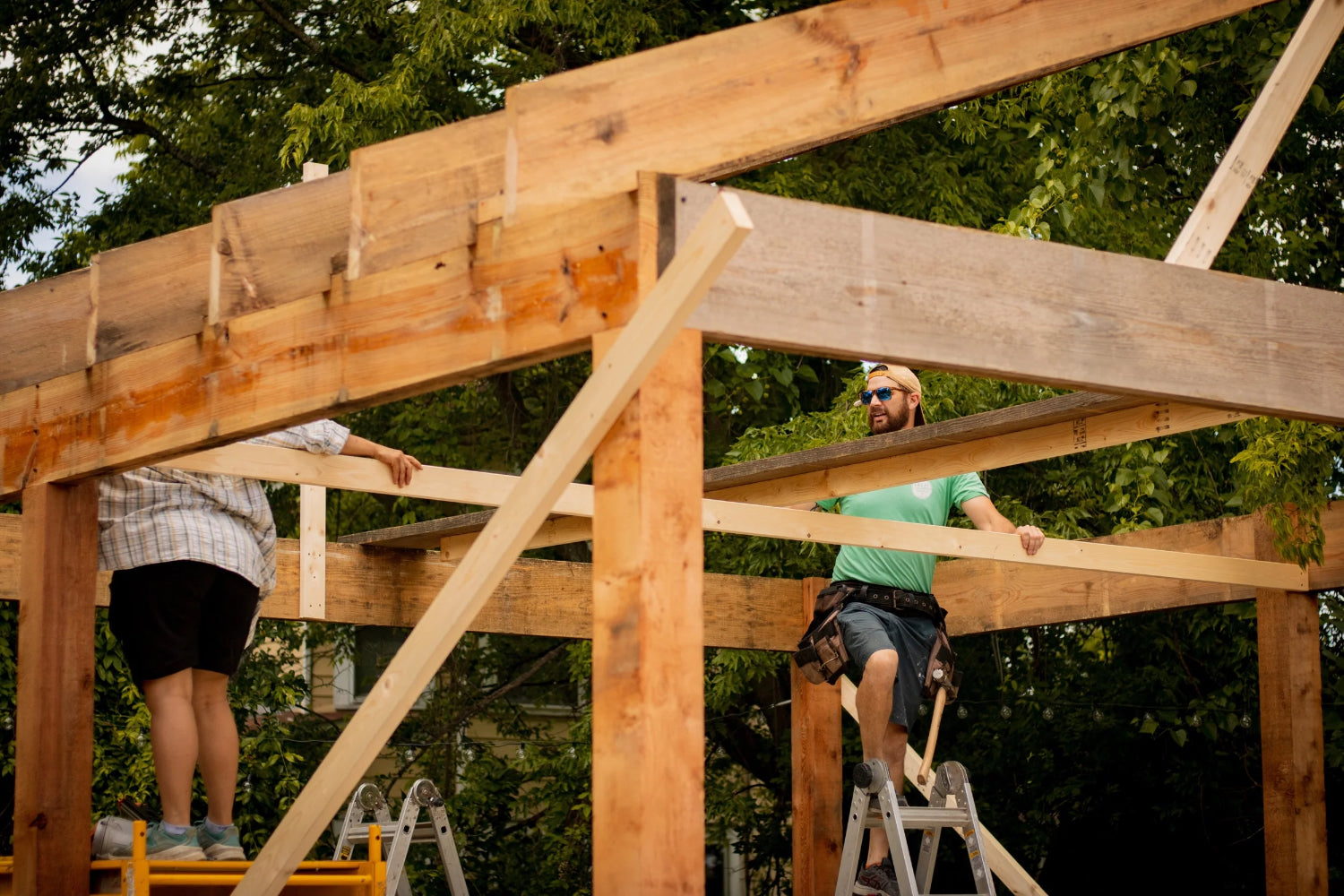 Two people work on framing a house