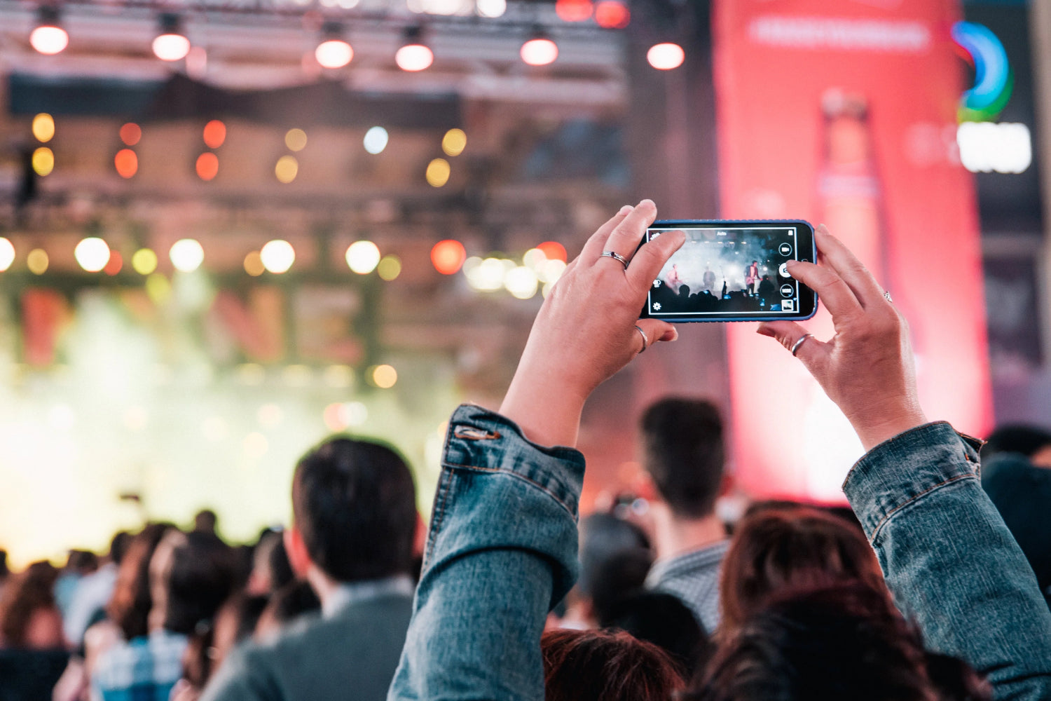 A person shoots a phone video at a concert