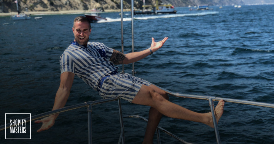 Male model wearing a Romperjack stripped romper on a boat.