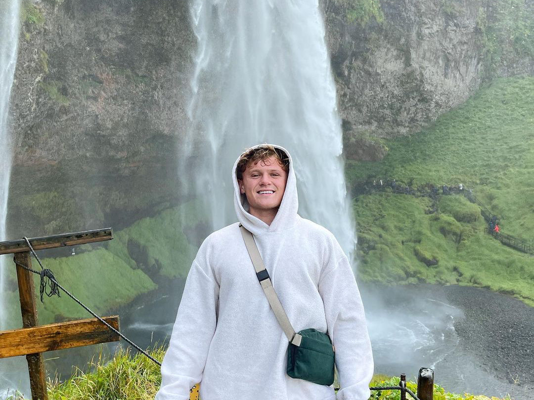 Portrait of YouTuber Ryan Trahan standing by a waterfall