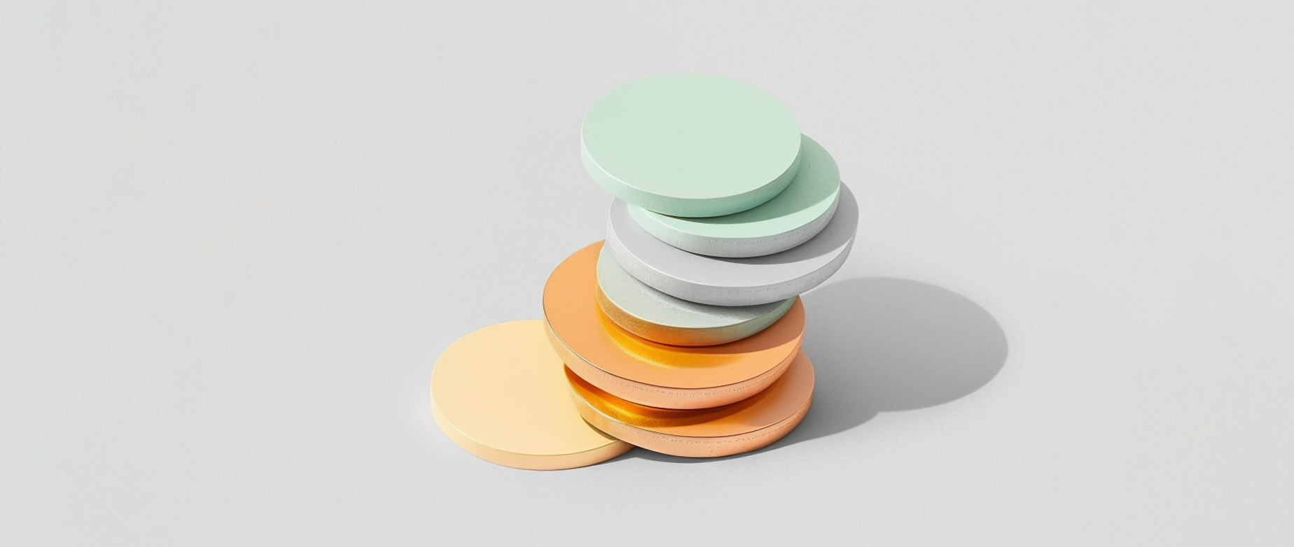 a stack of yellow, gold, gray, and mint green discs