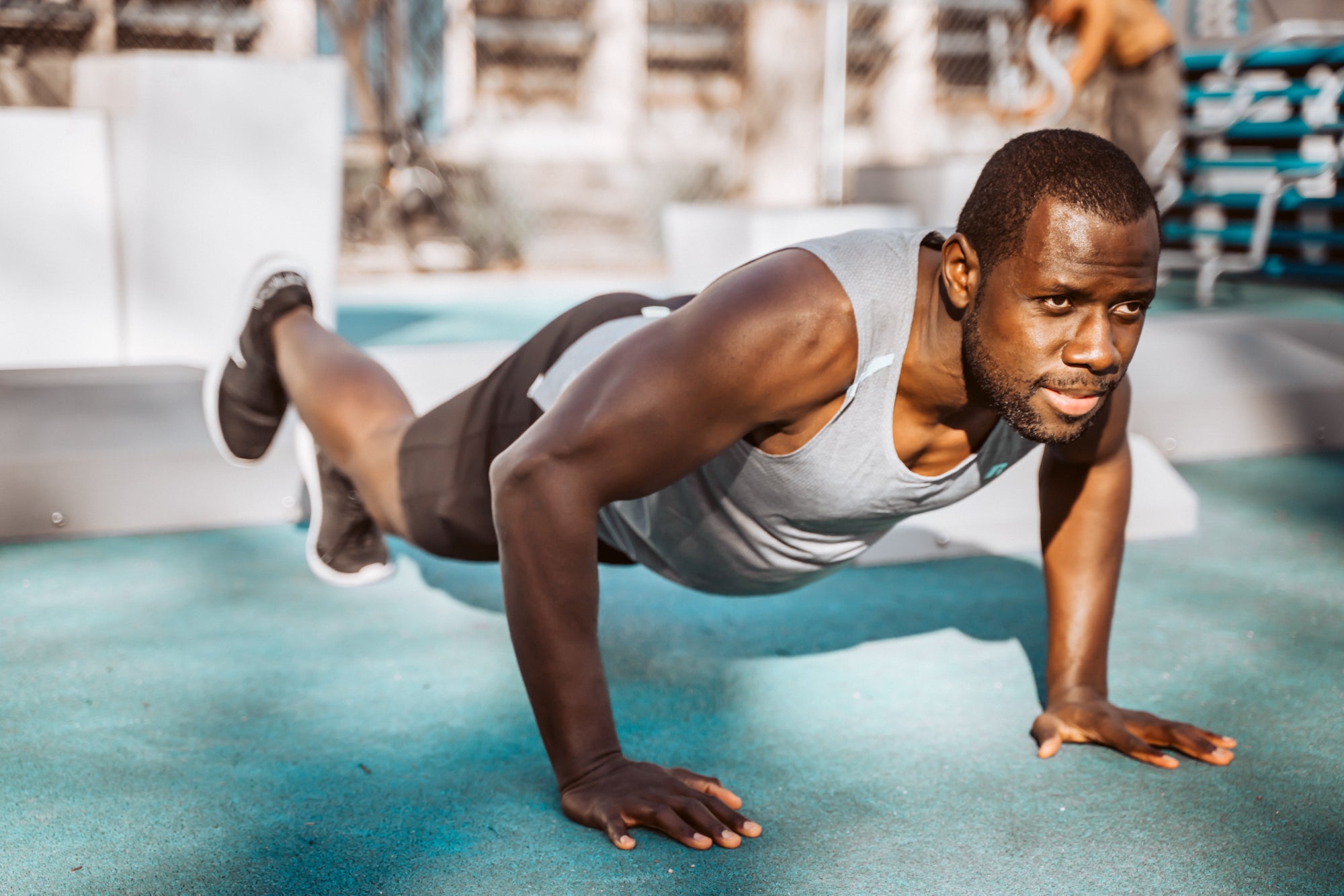 A person does a pushup in an outdoor gym