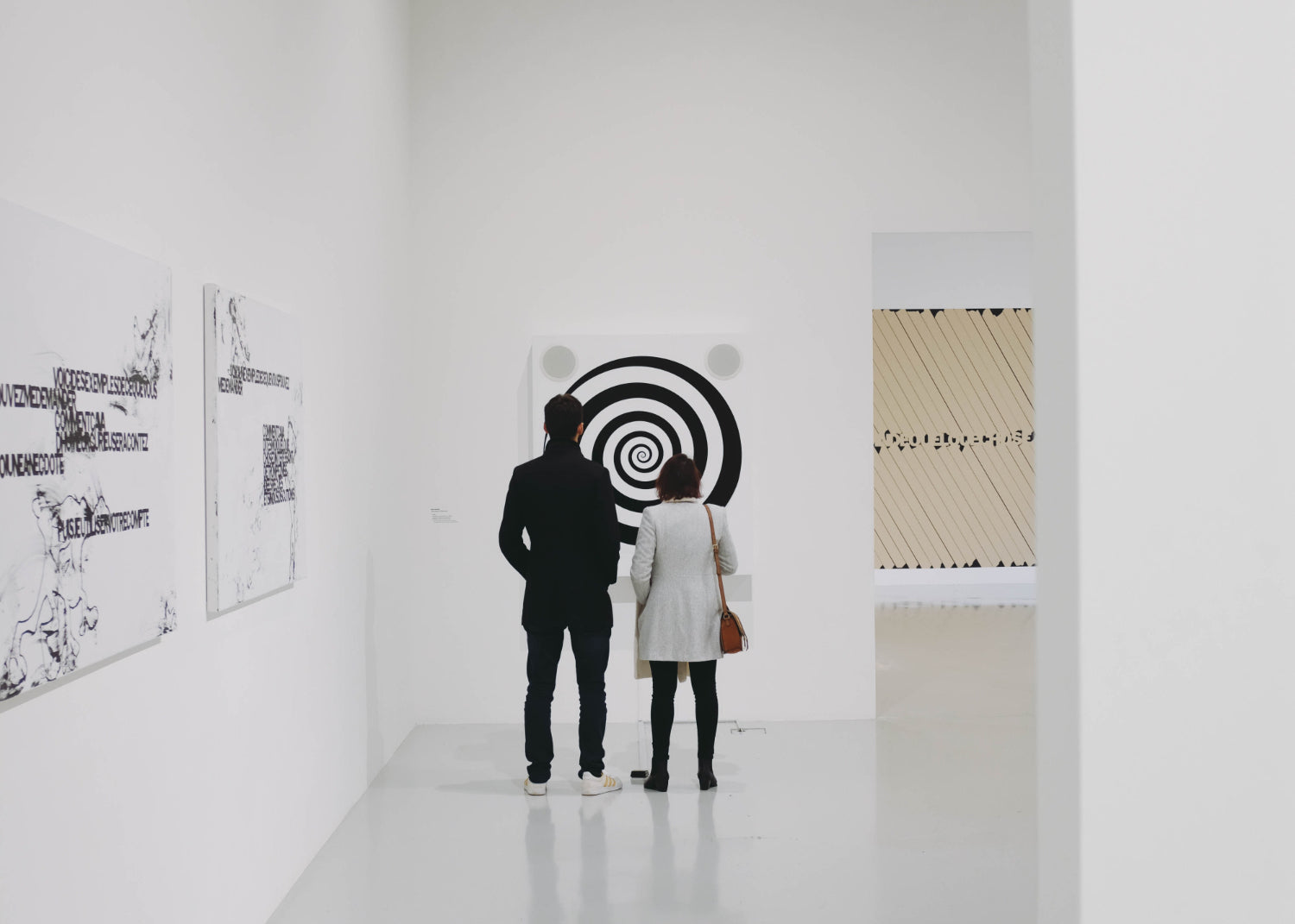 Two people look at art in a contemporary gallery