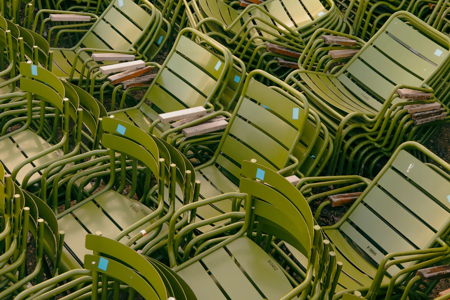 Stacks of green metal chairs in a warehouse