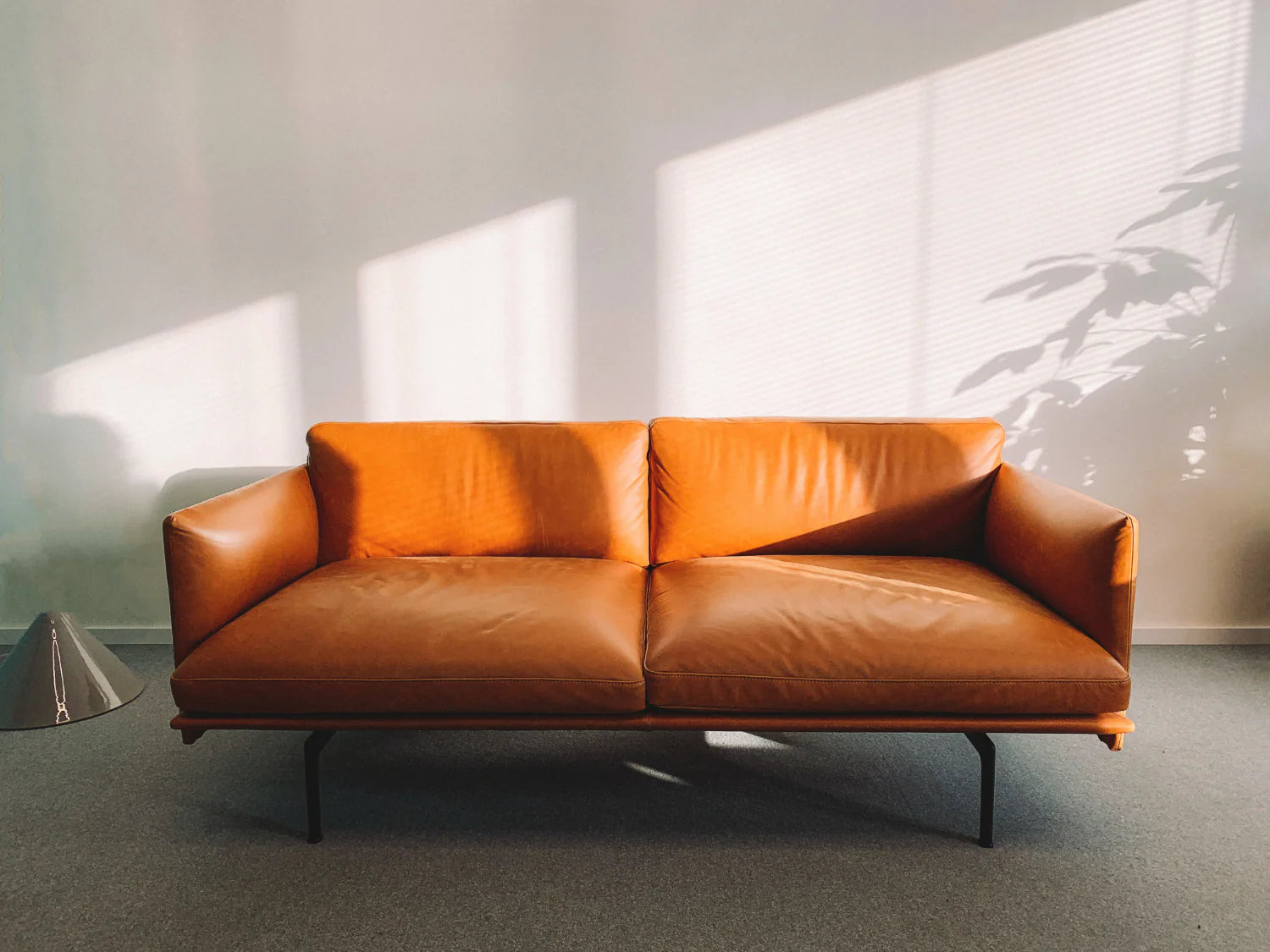 A brown leather couch in an empty room