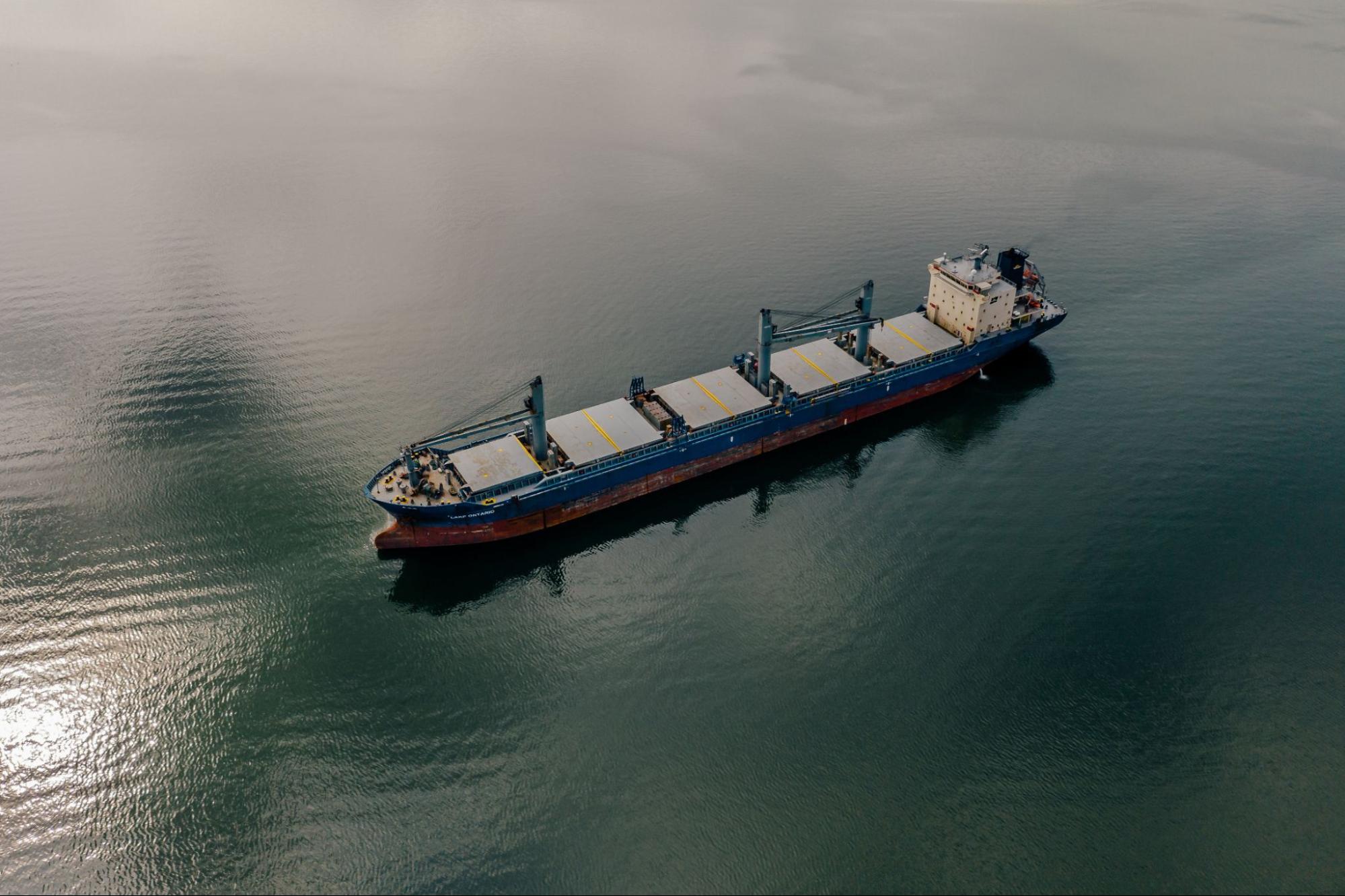 Shipping container moving through ocean waters on its way to port.