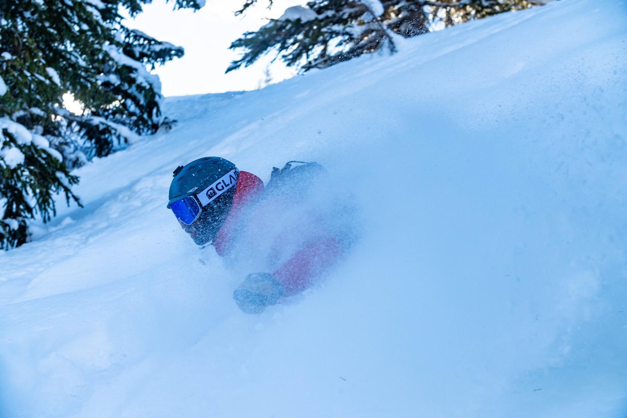 A skier deep in snow wearing Glade Optics. 