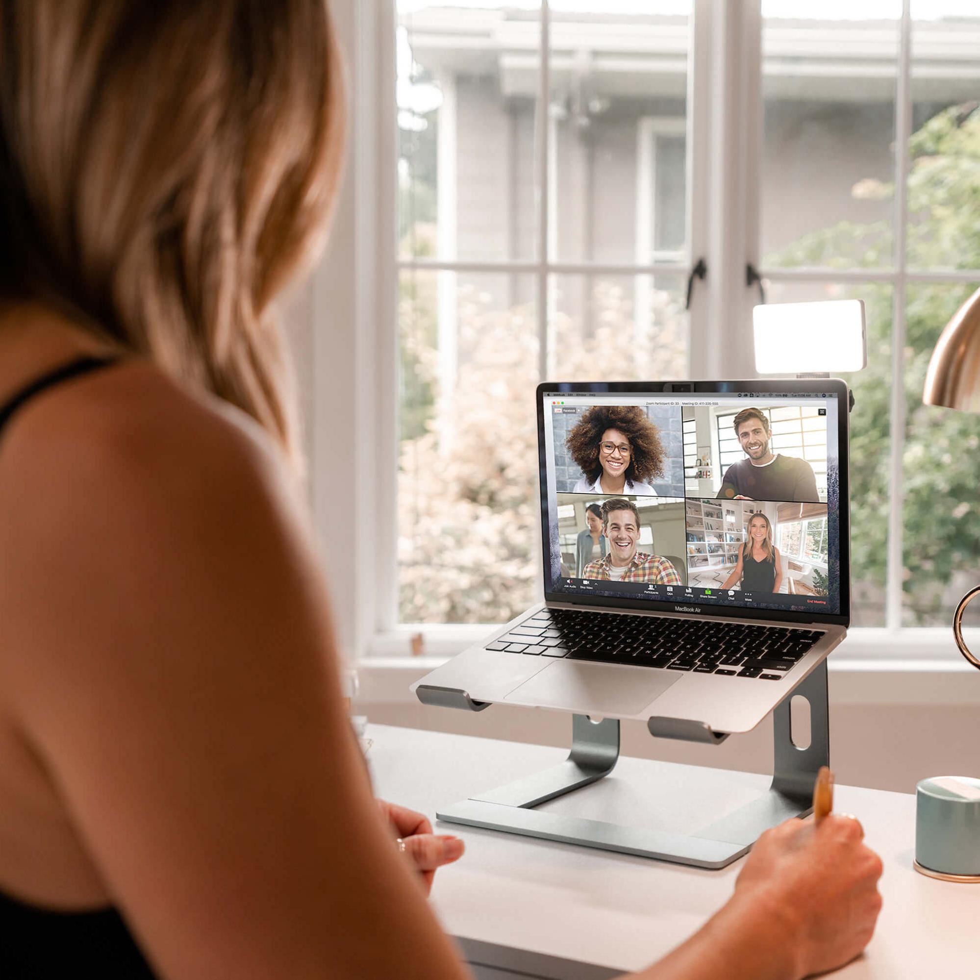 A model on a conference call with her laptop that has a Lume Cube lights attachment.