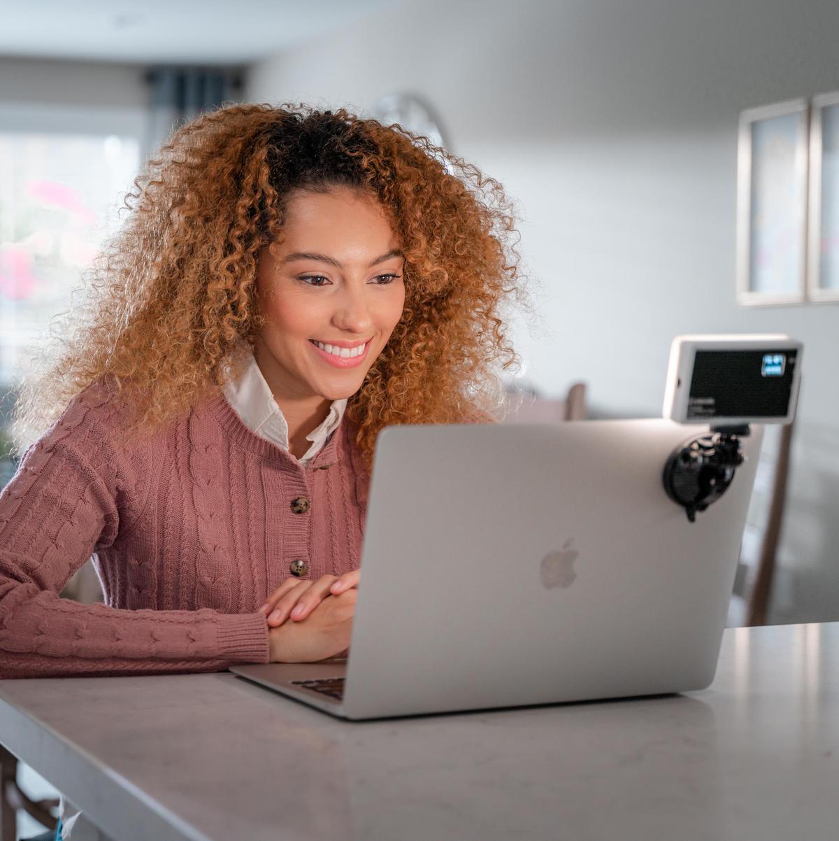 A model with a laptop along with a lights attachment from Lume Cube.