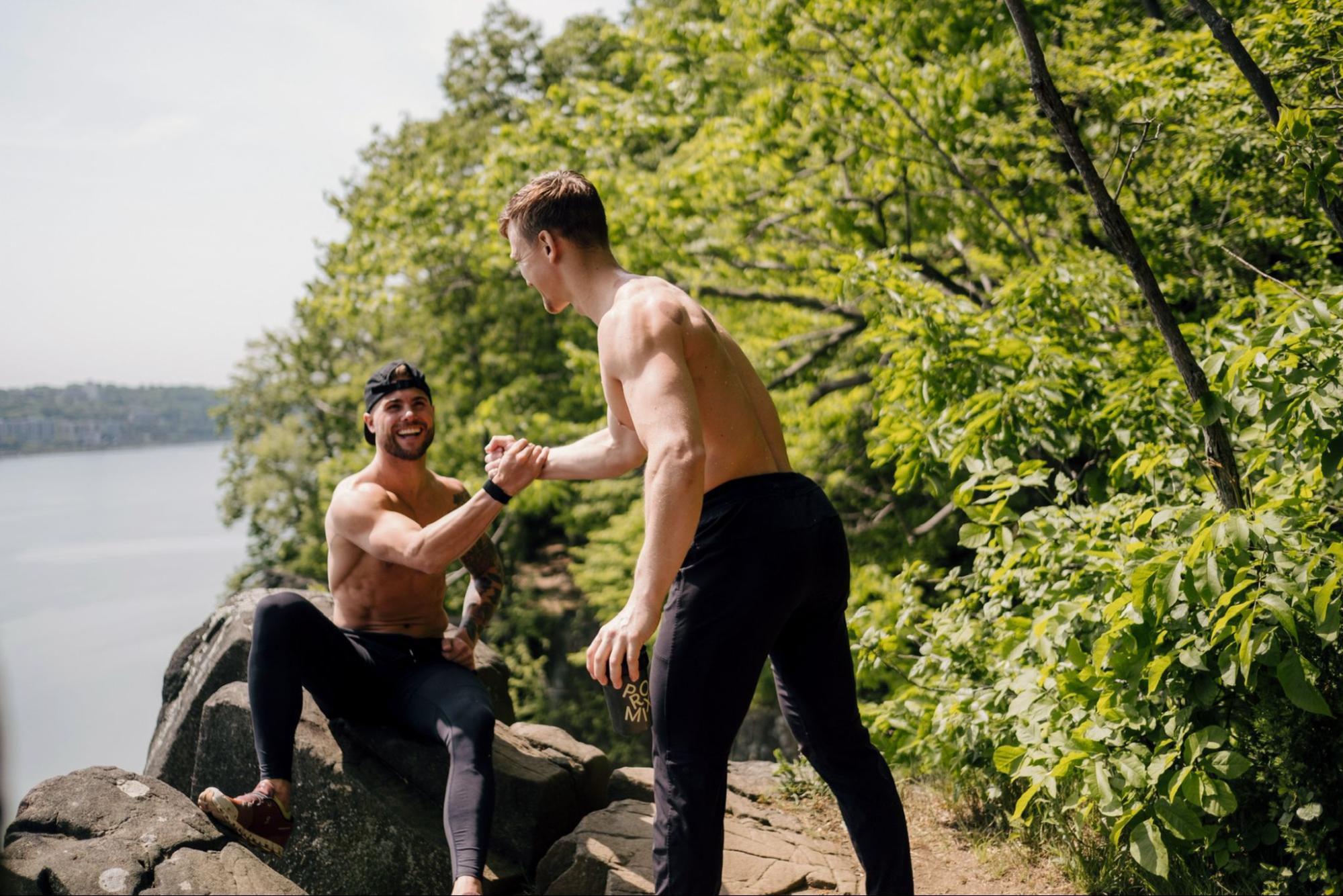 Two models greet each other in an outdoors setting.