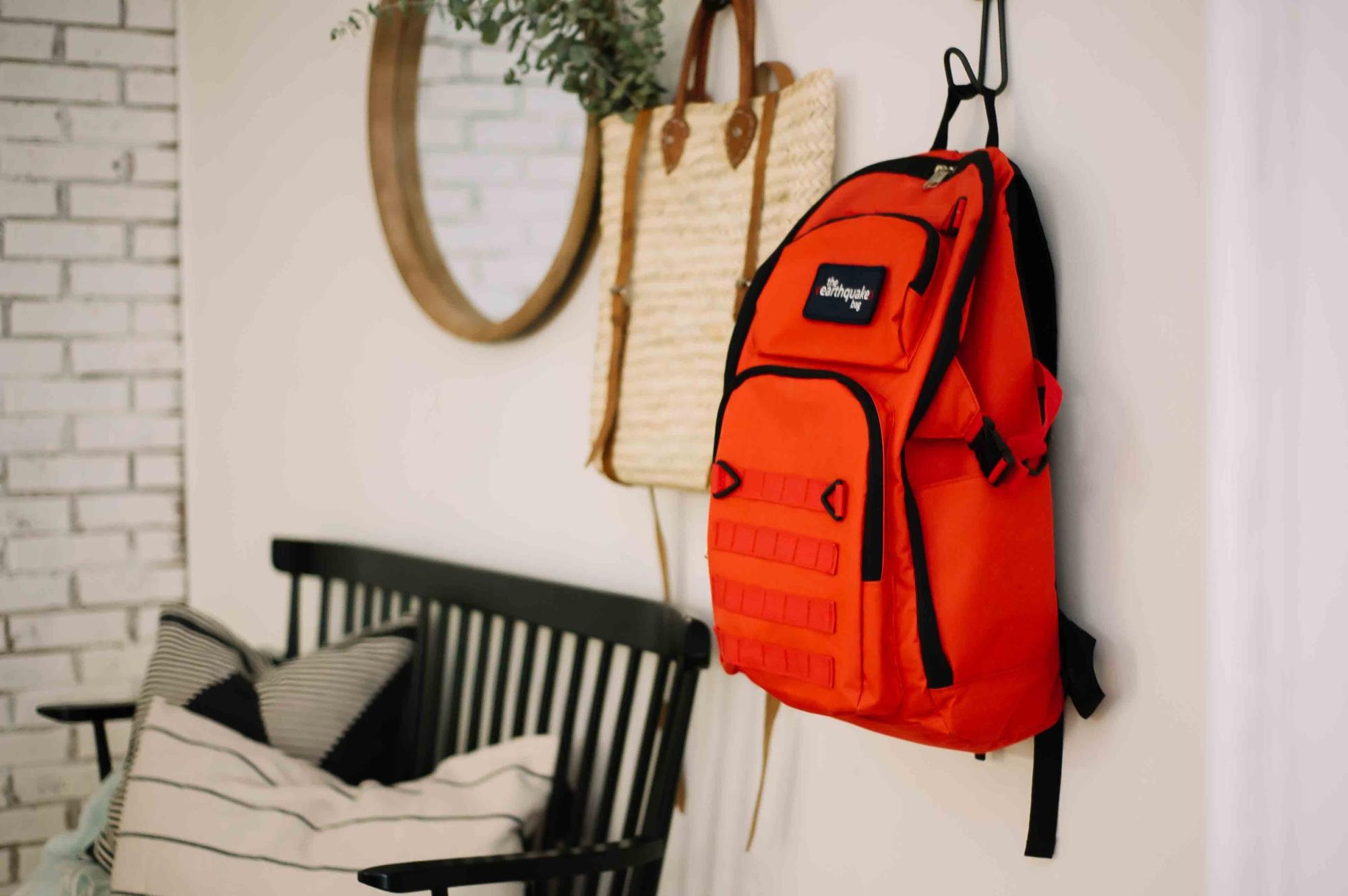 A Redfora backpack with emergency supplies on a coat hanger.