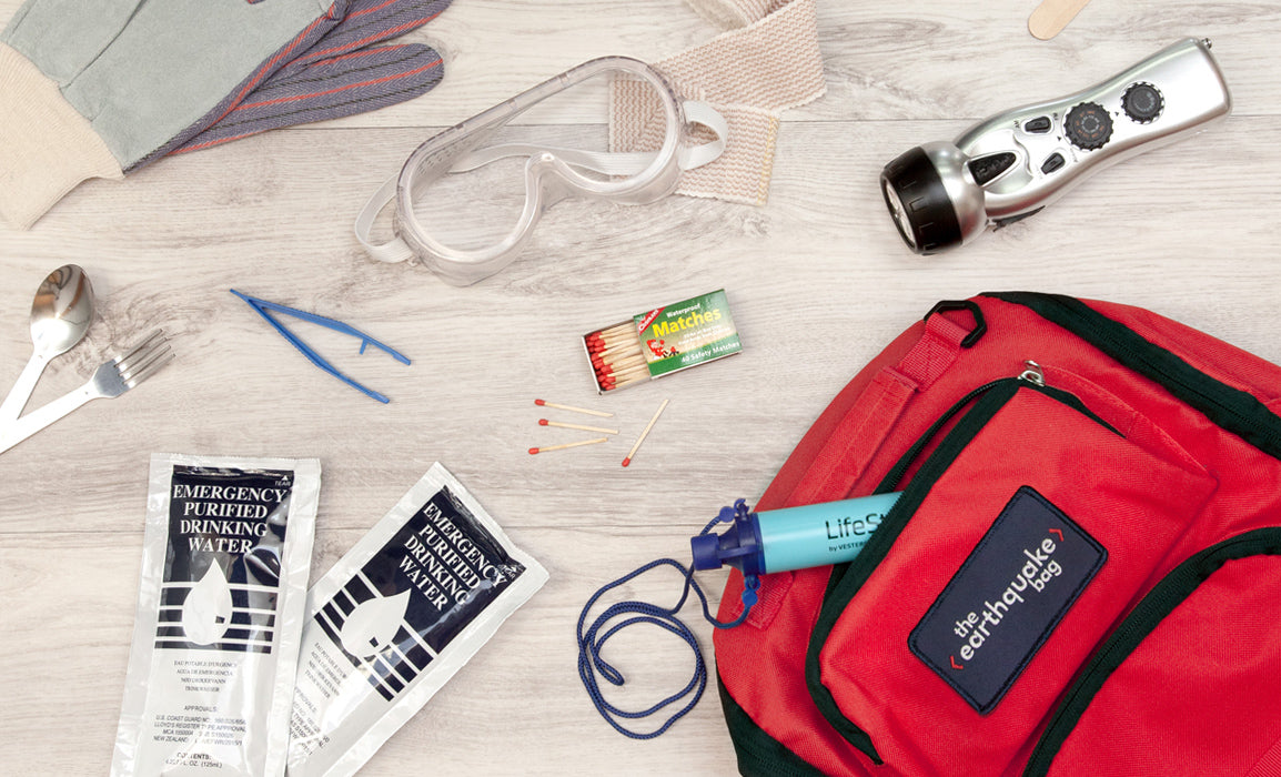 A Redfora earthquake bag is laid out with its contents of purified water, matches, googles, flashlight and gloves.