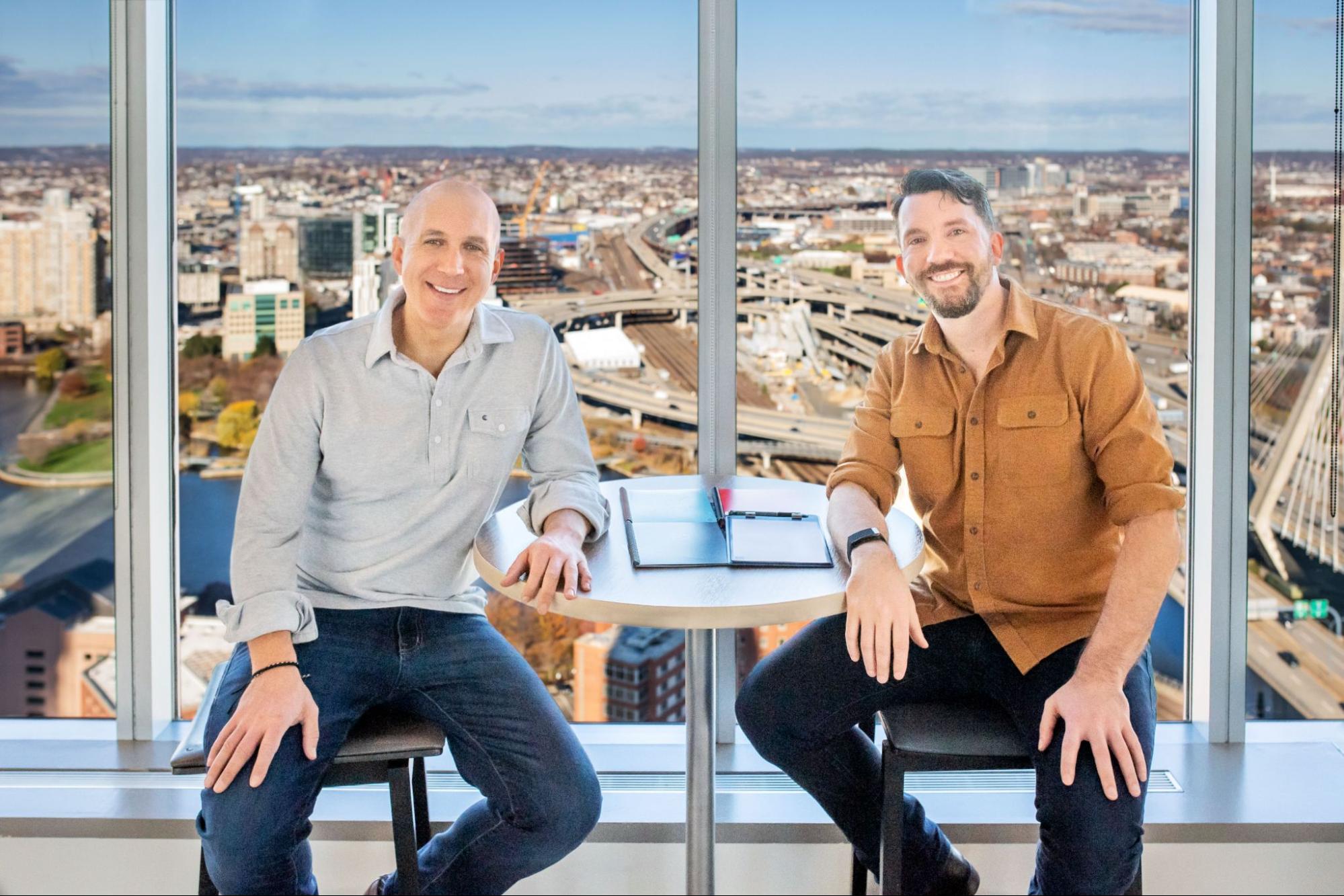 Joe Lamey and Jake Epstein sitting at a desk with their Rocketbooks. 