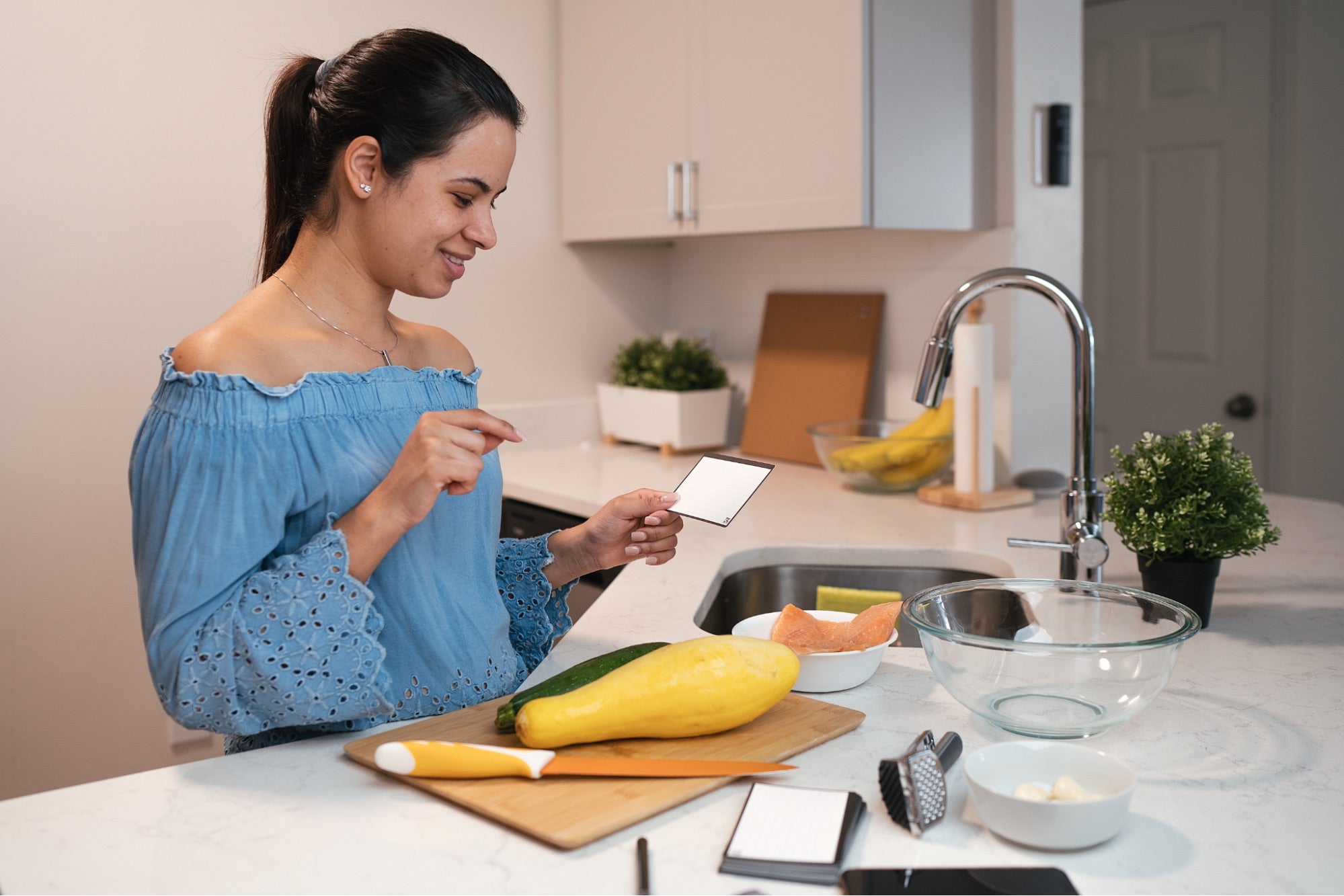  A female model using reusable note taking cards in the kitchen.