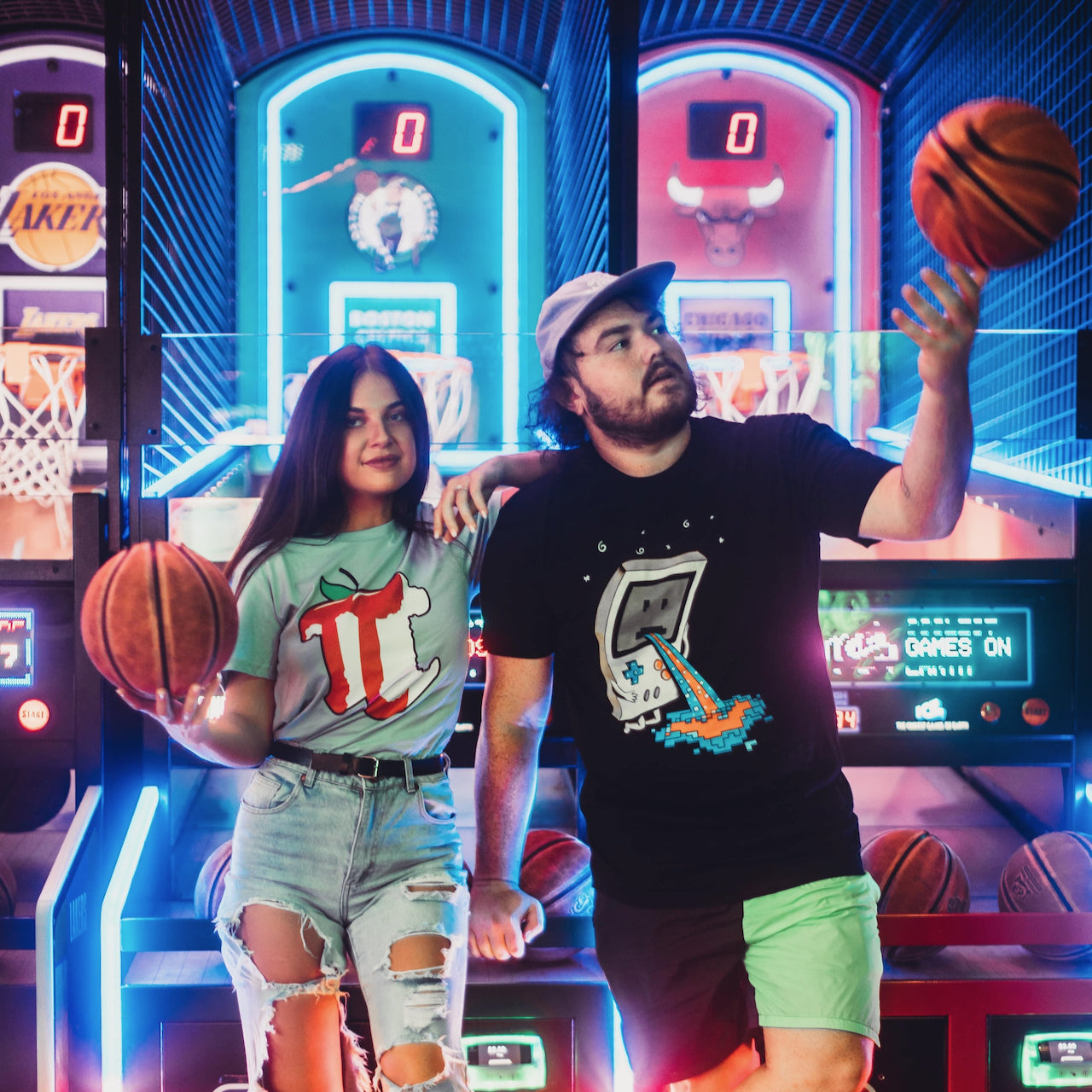 A pair of models in an arcade setting wearing T-shirts designed by Threadheads. 