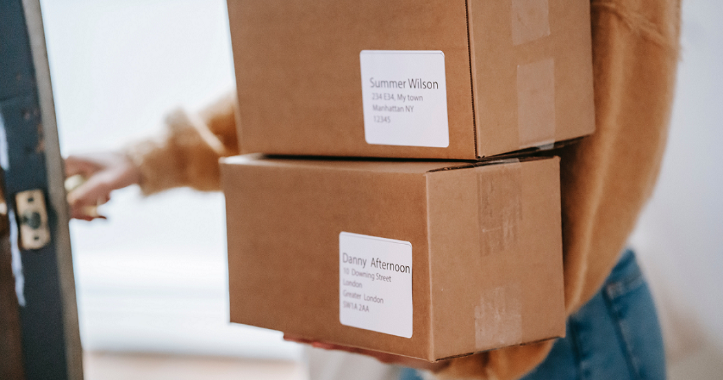 Person holding two boxes headed out the door